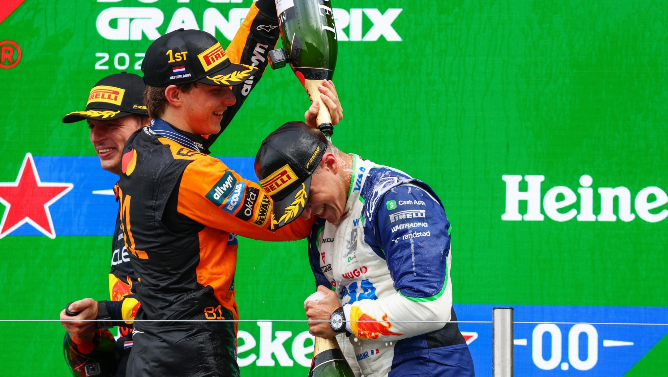 Race winner Oscar Piastri of Australia and McLaren pours champagne over Third placed Isack Hadjar of France and Visa Cash App Racing Bulls on the podium during the F1 Grand Prix of Netherlands at Circuit Zandvoort on August 31, 2025 in Zandvoort, Netherlands. (Photo by Clive Rose/Getty Images)