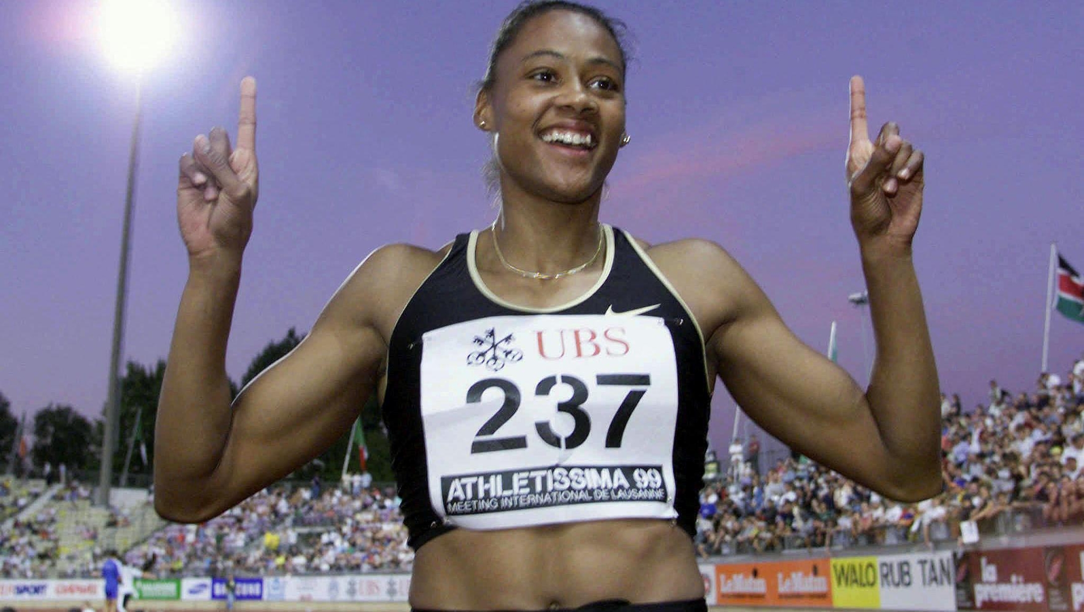 Marion Jones of the US jubilates after winning the women's 100 meters in the Athletissima Meeting in Lausanne 02 July 1999. Jones timed 10.80 seconds, beating Sevatheda Fynes of the Bahamas and Inger Miller of the US. electronic image (Photo by ALESSANDRO DELLA VALLE / Keystone via AFP)