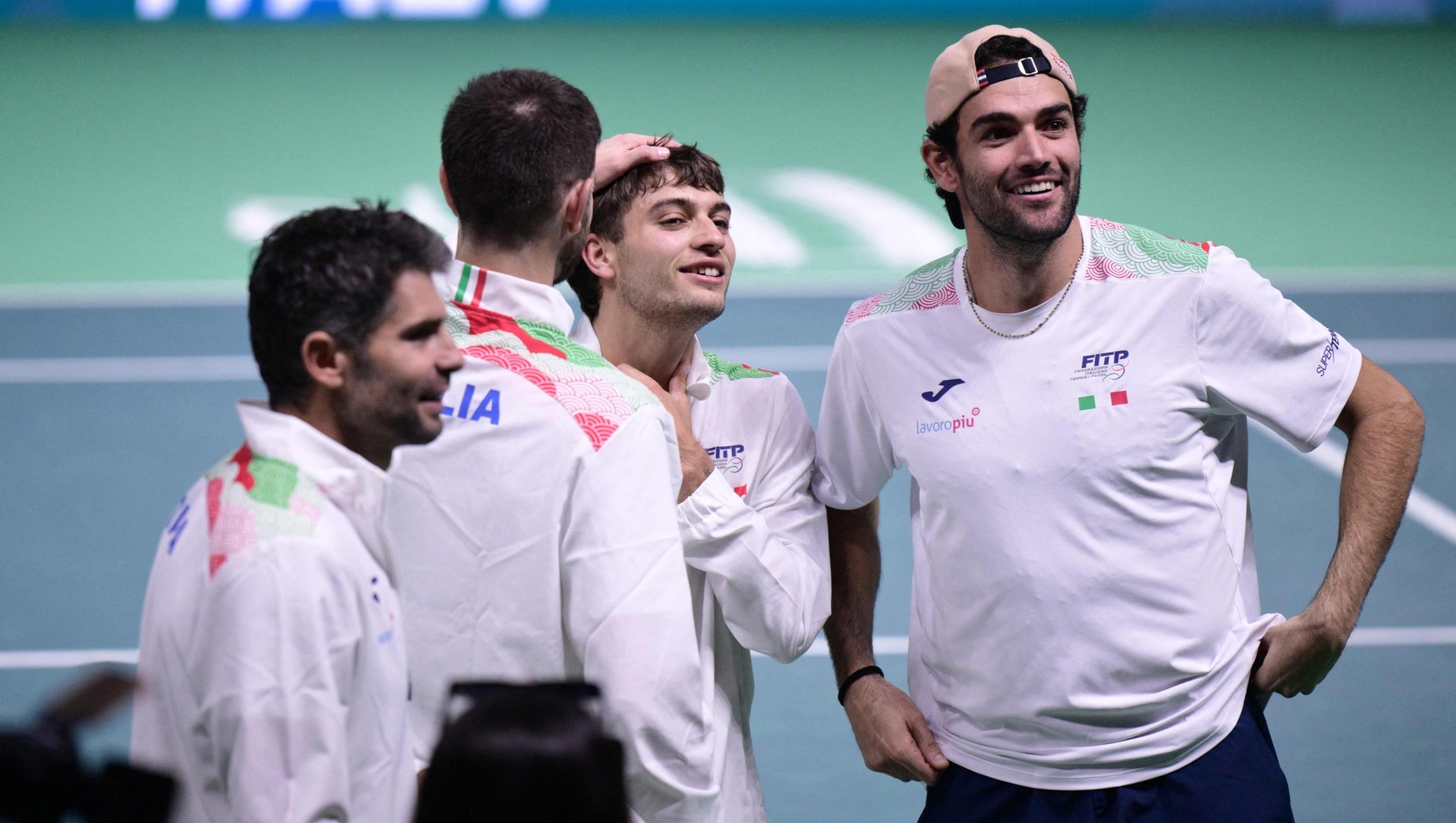 Italy's Flavio Cobolli (2nd R) is congratulated by Italy's Matteo Berrettini (R) and fellow team mates after winning his 2025 Davis Cup semi-final single tennis match between Italy and Belgium at the Super Tennis Arena in Bologna, northen Italy, on November 21, 2025. (Photo by Tiziana FABI / AFP)