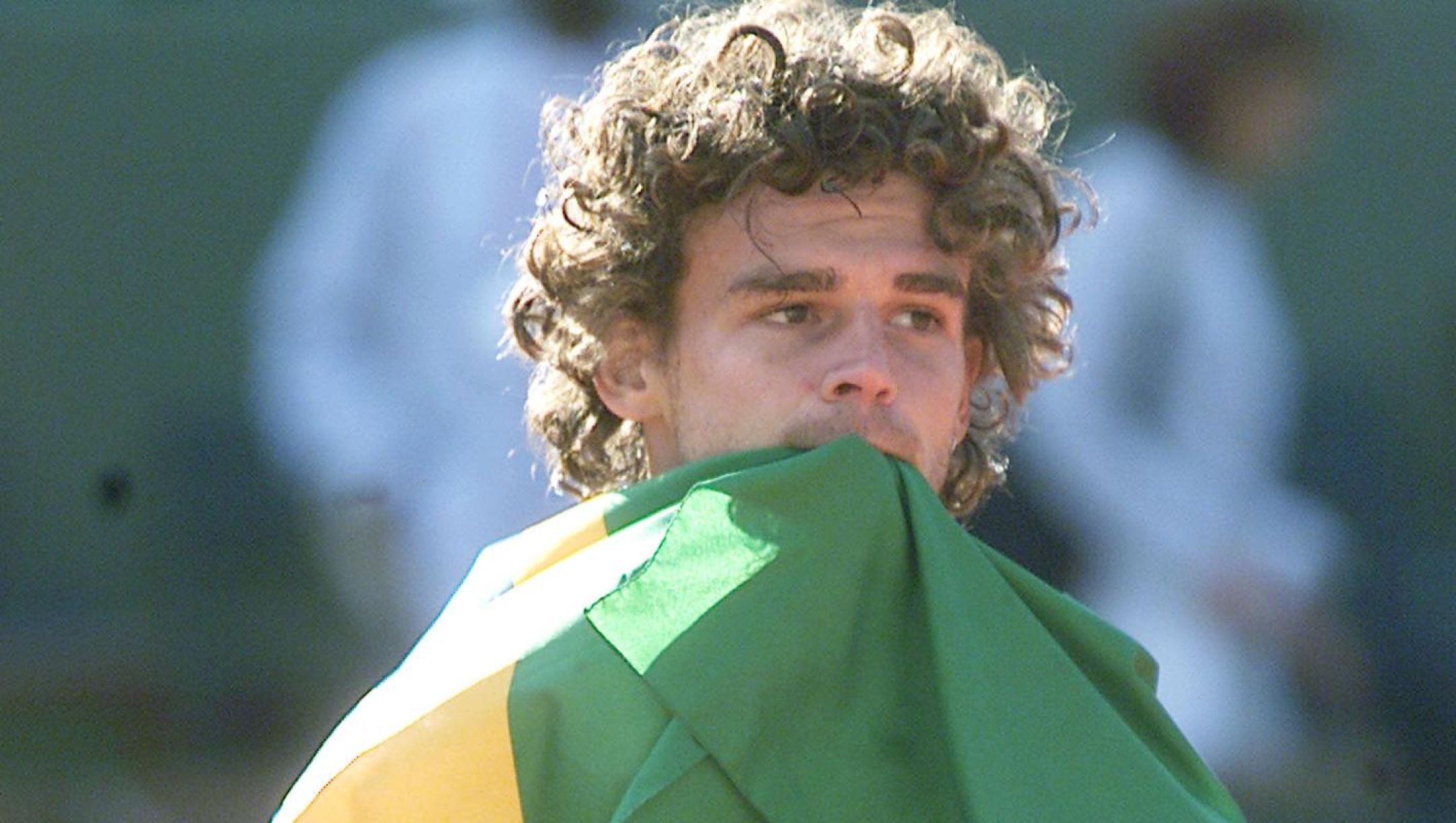 Brazil's Gustavo Kuerten, his national flag in his mouth, carries his trophy after winning the men's final of the French Tennis Open against  Spain's Alex Corretja at the Roland Garros stadium Sunday June 10, 2001 in Paris.(AP Photo/Dusan Vranic)