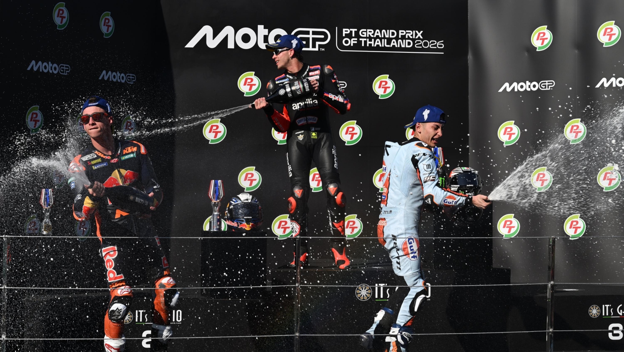 From left, second placed Spain's rider Pedro Acosta, MotoGP winner Italy's rider Marco Bezzecchi and third placed Spain's rider Raul Fernandez celebrate on the podium after the MotoGP at the Chang International Circuit in Buriram, Thailand, Sunday, March 1, 2026. (AP Photo/Kittinun Rodsupan)