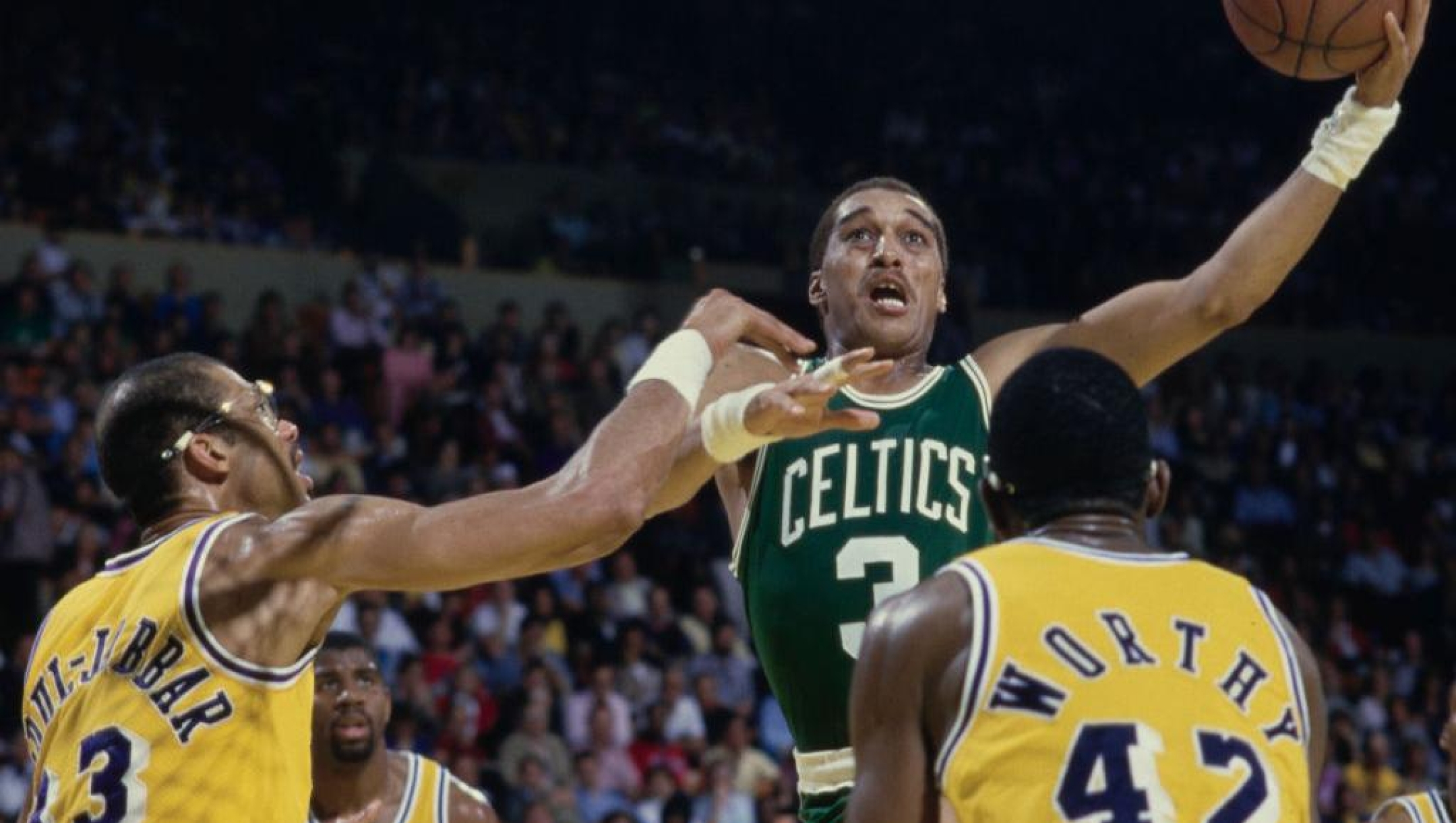 Dennis Johnson #3, Point Guard and Shooting Guard for the Boston Celtics jumps to make a one handed lay up to the basket as #42 James Worthy, #32 Magic Johnson and #33 Kareem Abdul-Jabbar of the Los Angeles Lakers look on during their NBA Pacific Division basketball game on 16th February 1986 at The Forum arena in Inglewood, Los Angeles, California, United States. The Celtics won the game 105 - 99. (Photo by Rick Stewart/Allsport/Getty Images)
