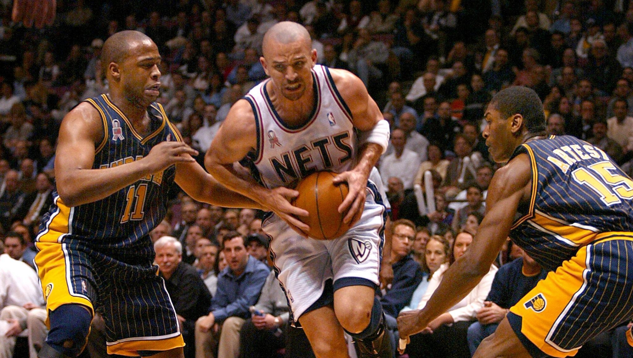 Jamaal Tinsley (L) and Ron Artest (R) of the Indiana Pacers try to stop Jason Kidd (C) of the New Jersey Nets during their NBA Eastern Conference playoff game 22 April, 2002 in East Rutherford, NJ.   AFP PHOTO/Matt CAMPBELL (Photo by MATT CAMPBELL / AFP)