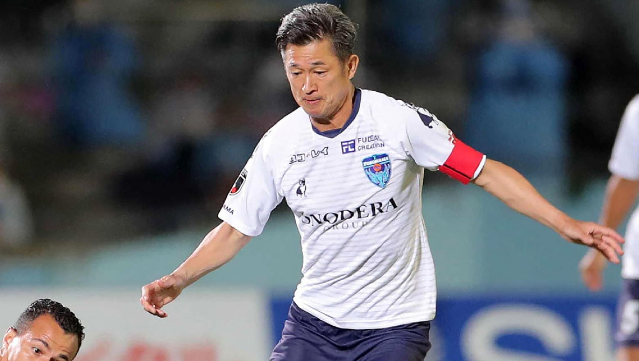 (FILES) Yokohama FC forward Kazuyoshi Miura (R) is tackled by Kawasaki Frontale forward Leandro Damiao during the J-League football match between Kawasaki Frontale and Yokohama FC at Todoroki Athletics stadium in Kawasaki on September 23, 2020. The 59-year-old former Japan striker Kazuyoshi Miura scored his first competitive goal in almost four years when his Fukushima United side strolled to a 7-0 win on July 25, 2026. (Photo by JIJI PRESS / AFP) / Japan OUT