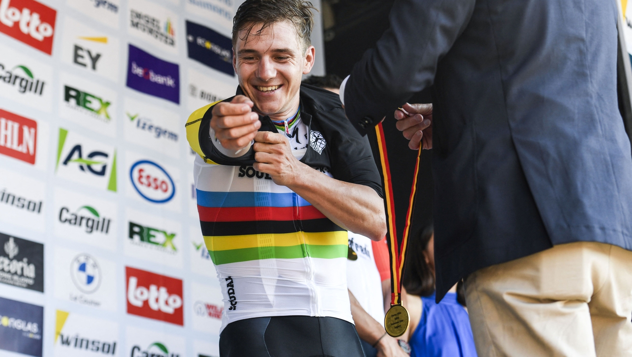 Belgium's Remco Evenepoel of Soudal Quick-Step puts on his Belgian champion's jersey over his World champion's jersey, as he celebrates on the podium after winning the men's 230,7 km elite race of the Belgian Cycling Championship, in Izegem, on June 25, 2023. (Photo by Tom GOYVAERTS / Belga / AFP) / Belgium OUT