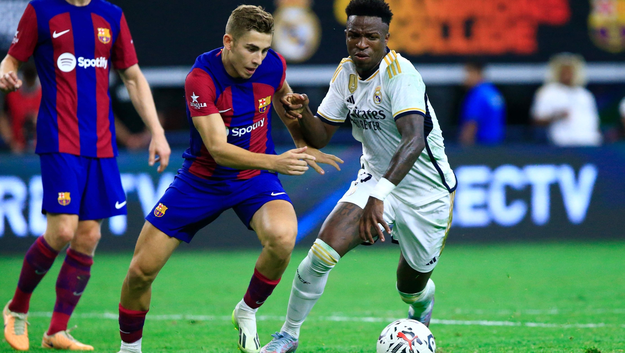 Real Madrid's Brazilian forward Vini Jr. (R) vies for the ball with Barcelona' Spanish forward Fermin Lopez during a pre-season friendly football match between FC Barcelona and Real Madrid CF at AT&T Stadium in Arlington, Texas on July 29, 2023. (Photo by Aric Becker / AFP)