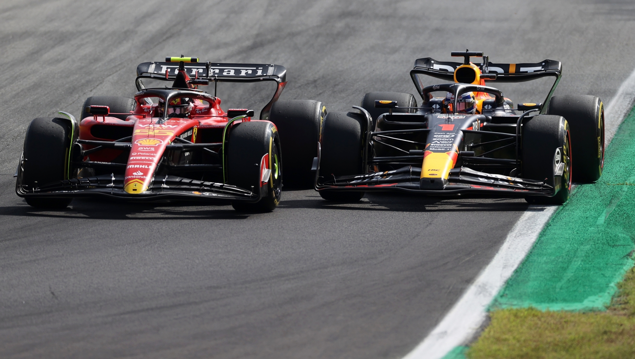 MONZA, ITALY - SEPTEMBER 03: Carlos Sainz of Spain driving (55) the Ferrari SF-23 and Max Verstappen of the Netherlands driving the (1) Oracle Red Bull Racing RB19 battle for track position during the F1 Grand Prix of Italy at Autodromo Nazionale Monza on September 03, 2023 in Monza, Italy. (Photo by Ryan Pierse/Getty Images)