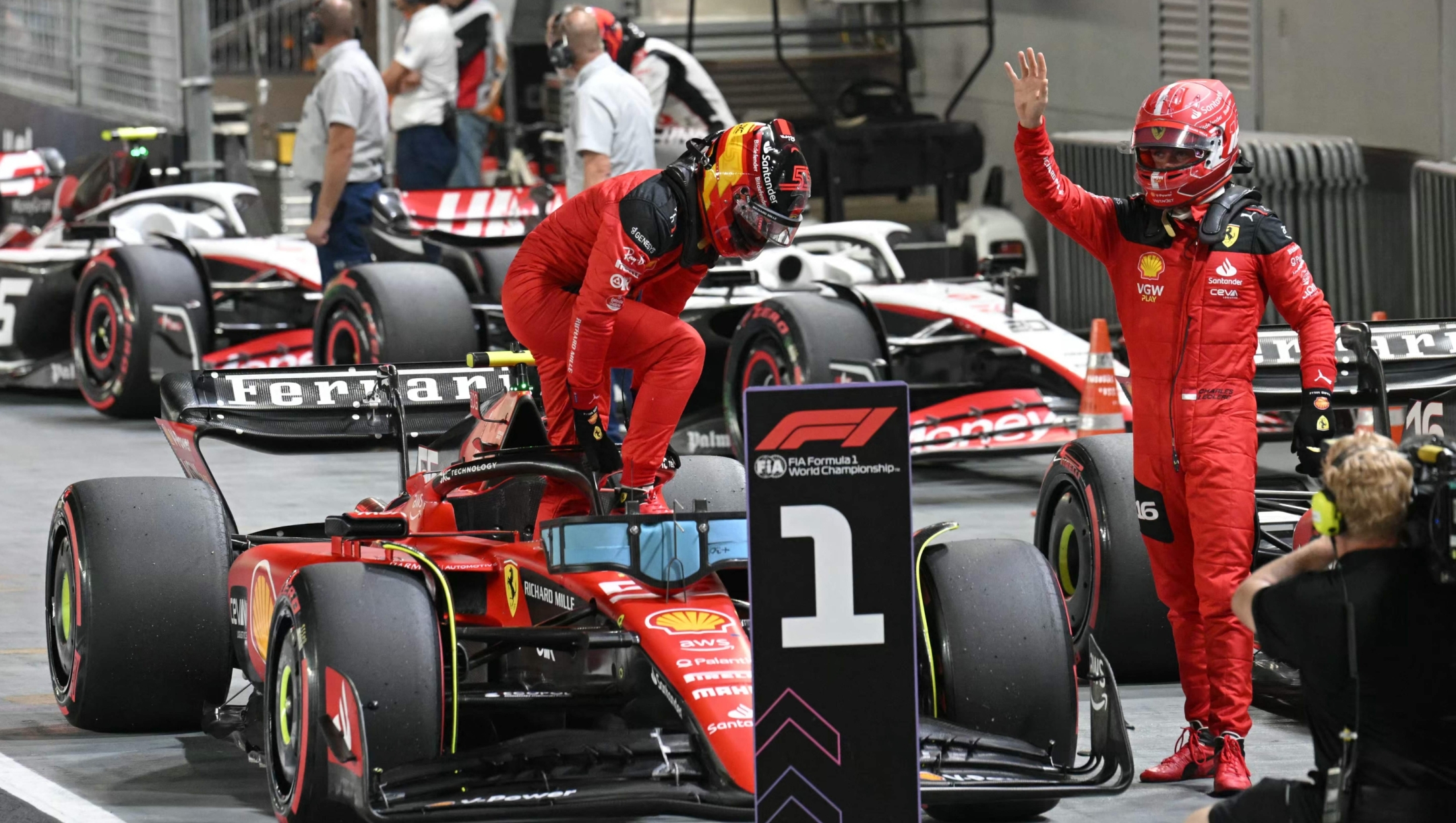 Ferrari's Monegasque driver Charles Leclerc (R) gestures as Ferrari's Spanish driver Carlos Sainz Jr gets out of his car after the qualifying session of the Singapore Formula One Grand Prix night race at the Marina Bay Street Circuit in Singapore on September 16, 2023. (Photo by MOHD RASFAN / AFP)
