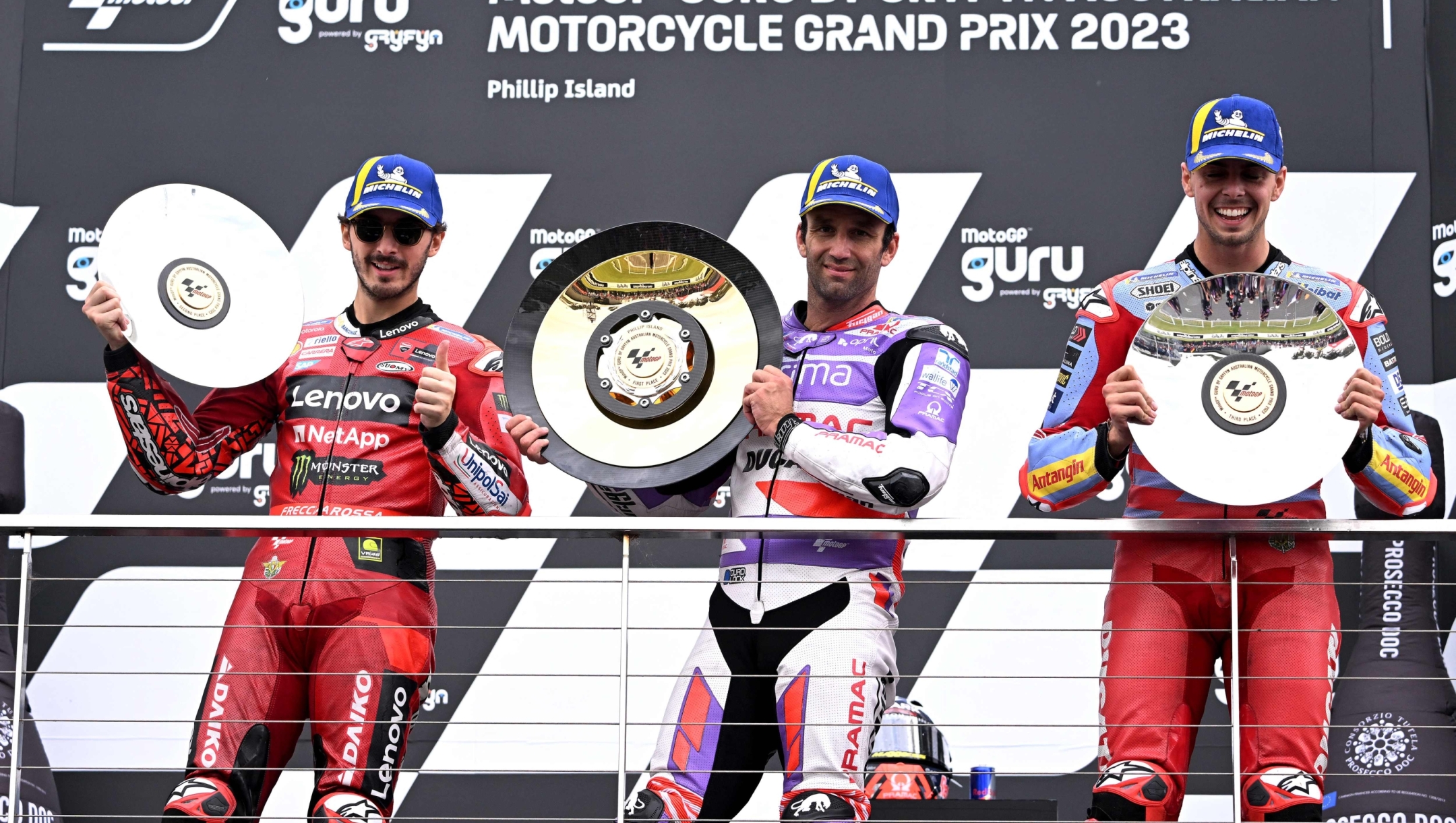 Winner Prima Pramac's French rider Johann Zarco (C) poses with second placed Ducati Lenovo Team's Italian rider Francesco Bagnaia (L) and third placed Gresini Racing's Italian rider Fabio Di Giannantonio on the podium after the MotoGP Australian Grand Prix at Phillip Island on October 21, 2023. (Photo by WILLIAM WEST / AFP) / -- IMAGE RESTRICTED TO EDITORIAL USE - STRICTLY NO COMMERCIAL USE --