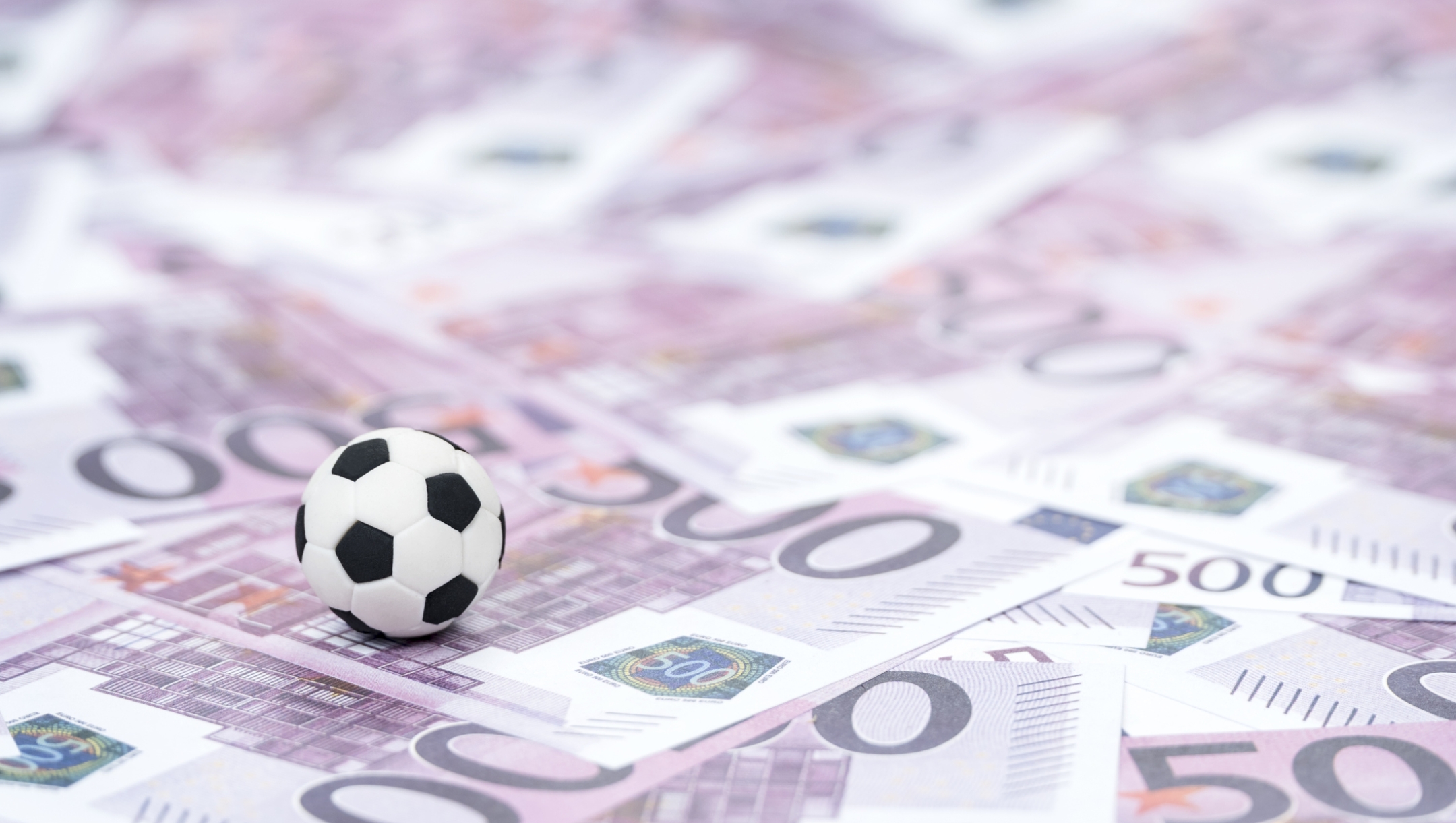 small soccer ball on money with a face value of five hundred euro