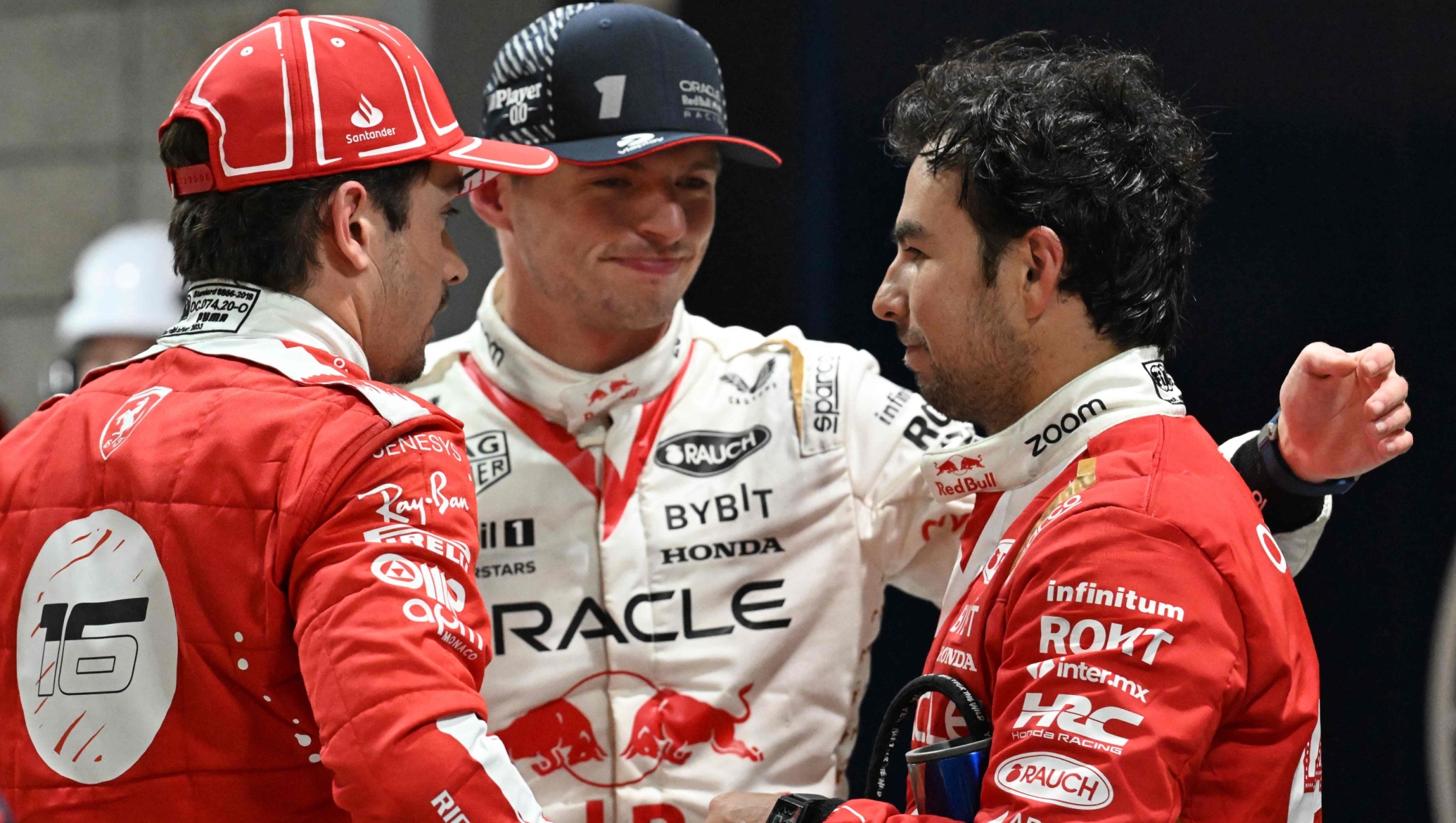 TOPSHOT - Winner Red Bull Racing's Dutch driver Max Verstappen (C) speaks with second place Ferrari's Monegasque driver Charles Leclerc (L) and third place Red Bull Racing's Mexican driver Sergio Perez races during the Las Vegas Formula One Grand Prix on November 18, 2023, in Las Vegas, Nevada. (Photo by Jim WATSON / AFP)