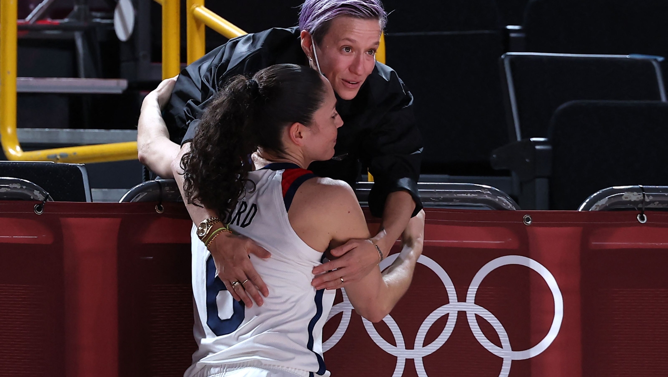 USA's football player Megan Rapinoe (R) greets USA's Sue Bird after the women's final basketball match between USA and Japan during the Tokyo 2020 Olympic Games at the Saitama Super Arena in Saitama on August 8, 2021. (Photo by Thomas COEX / AFP)