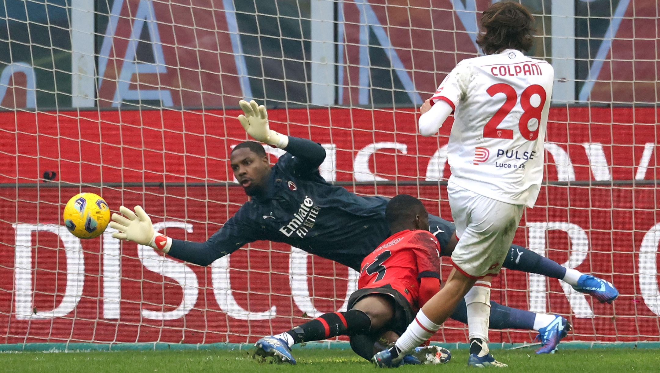 AC Milans goalkeeper Mike Maignan (L) saves on Monzas Andrea Colpani   during the Italian serie A soccer match between AC Milan and Monza at Giuseppe Meazza stadium in Milan, 17 December 2023. ANSA / MATTEO BAZZI