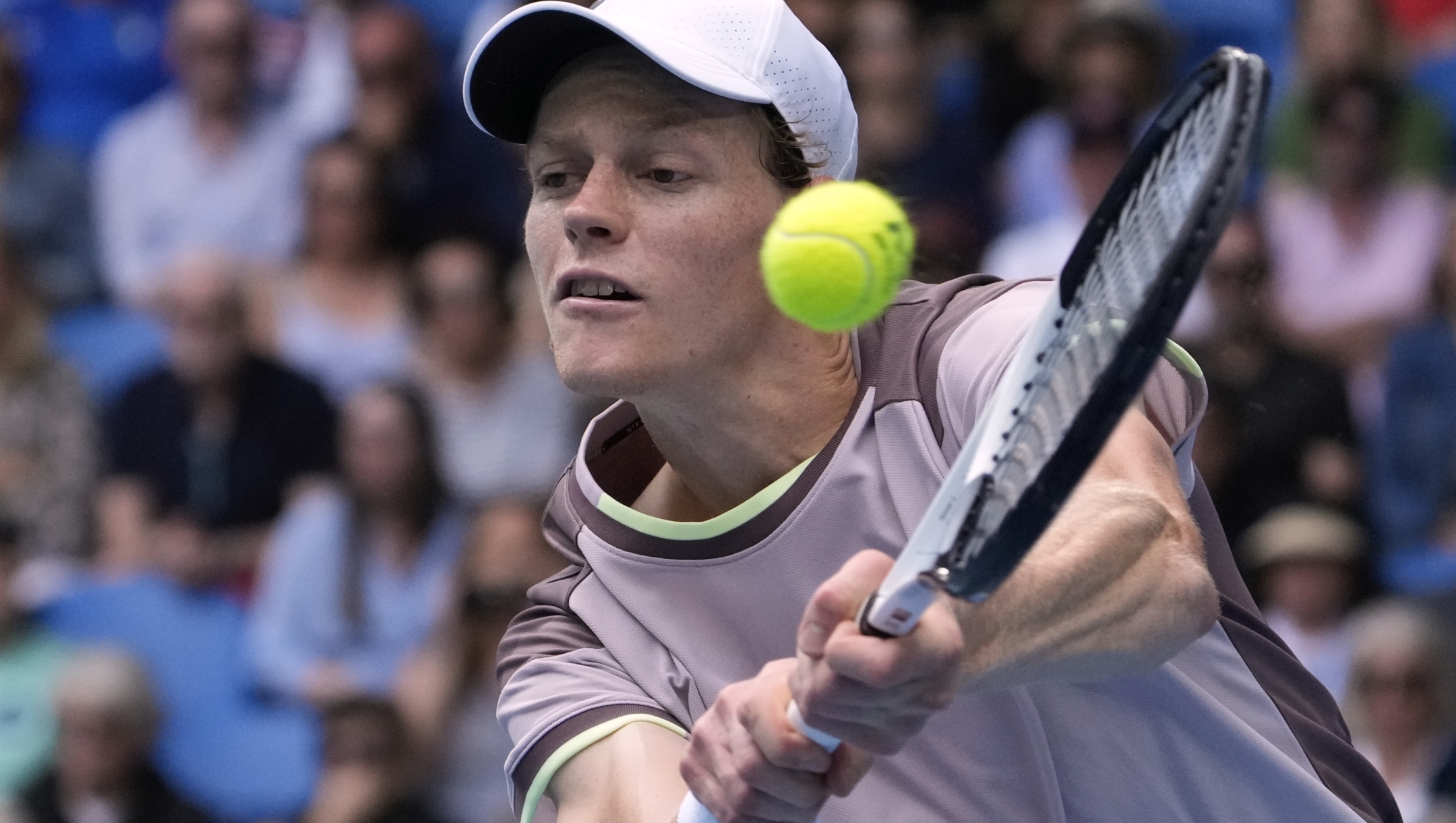 Jannik Sinner of Italy plays a backhand return to Sebastian Baez of Argentina during their third round match at the Australian Open tennis championships at Melbourne Park, Melbourne, Australia, Friday, Jan. 19, 2024. (AP Photo/Andy Wong)