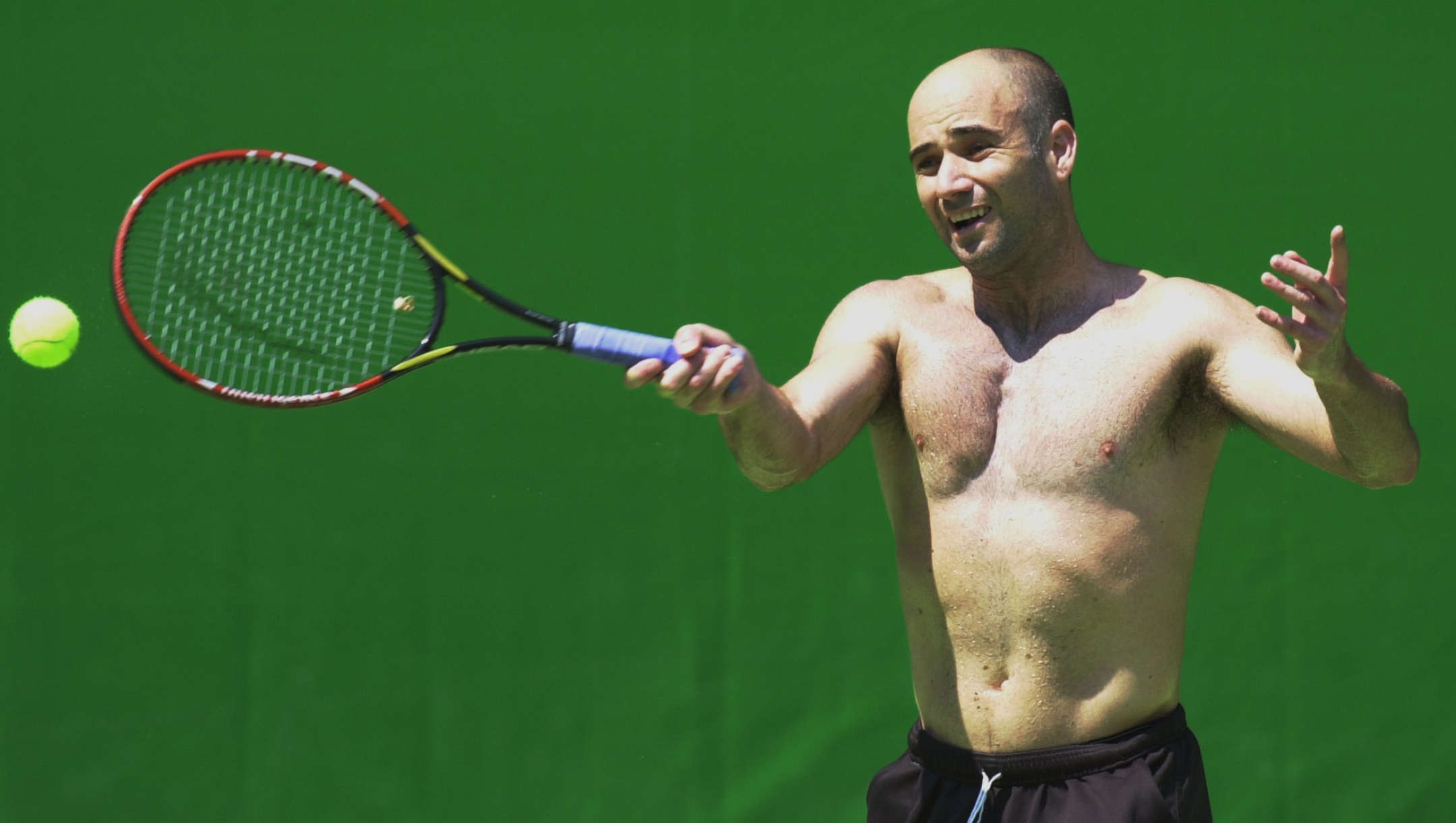 USA's Andre Agassi has his shirt off to combat the heat as he practices for the Australian Open tennis tournament in Melbourne, Sunday, Jan. 12, 2003. The tournament commences Monday Jan. 13. (AP Photo/Steve Holland)