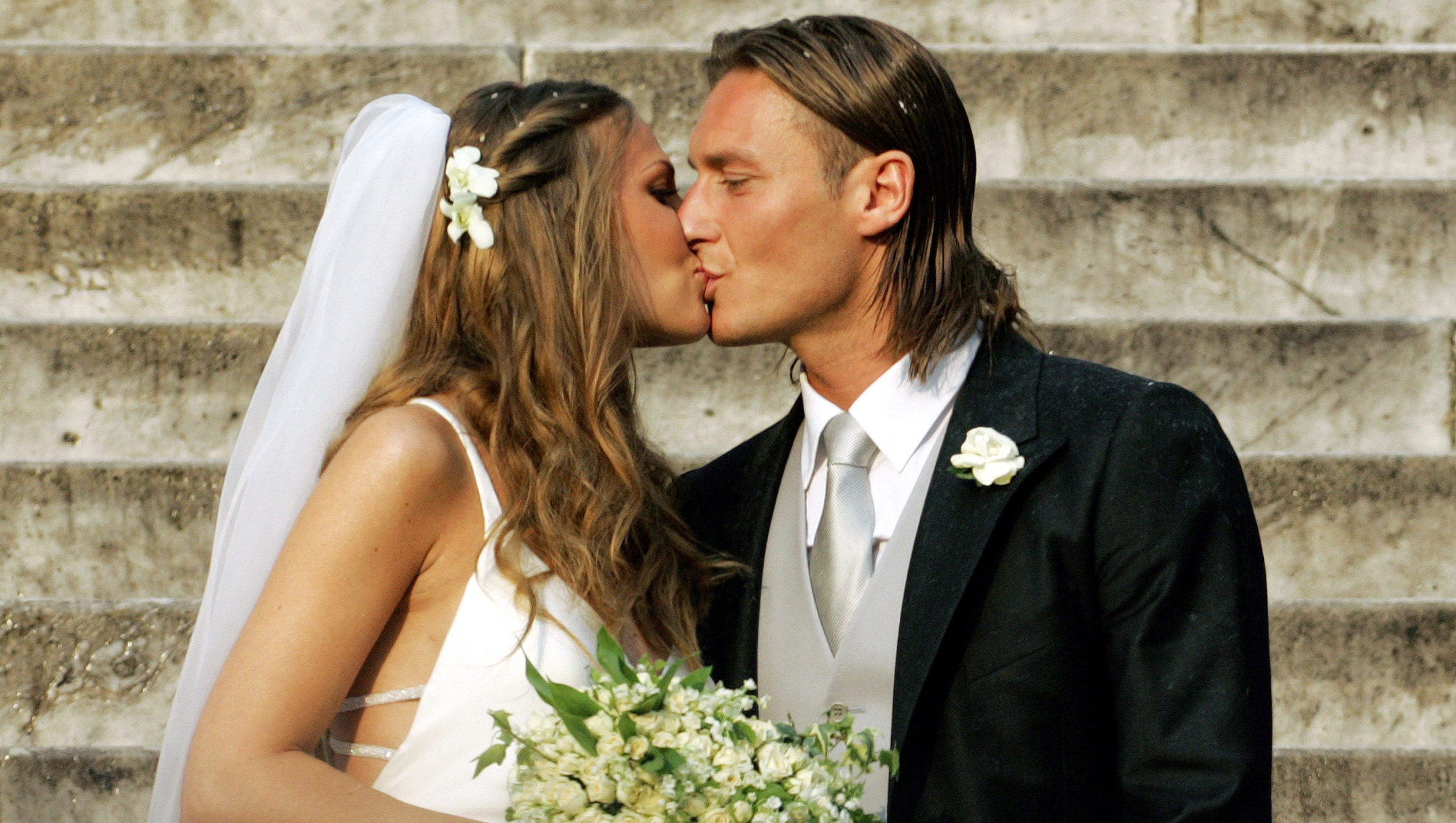 AS Roma captain Francesco Totti (R) kisses his wife Italian TV star Hilary Blasi after their wedding 19 June 2005 in Rome.  AFP PHOTO/Andreas SOLARO (Photo by ANDREAS SOLARO / AFP)
