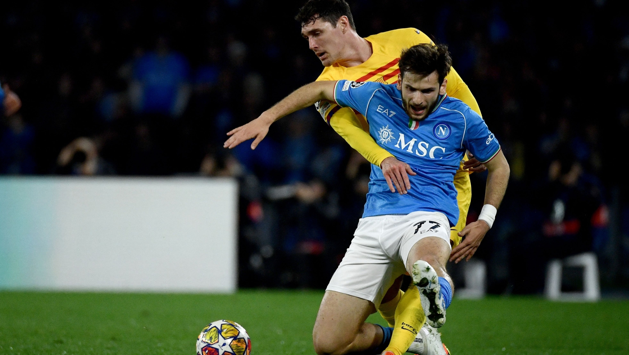 TOPSHOT - Napoli's Georgian forward #77 Khvicha Kvaratskhelia (R) vies with Barcelona's Danish defender #15 Andreas Christensen (L) during the UEFA Champions League round of 16 first Leg football match between Napoli and Barcelona at the Diego-Armando-Maradona stadium in Naples on February 21, 2024. (Photo by Filippo MONTEFORTE / AFP)