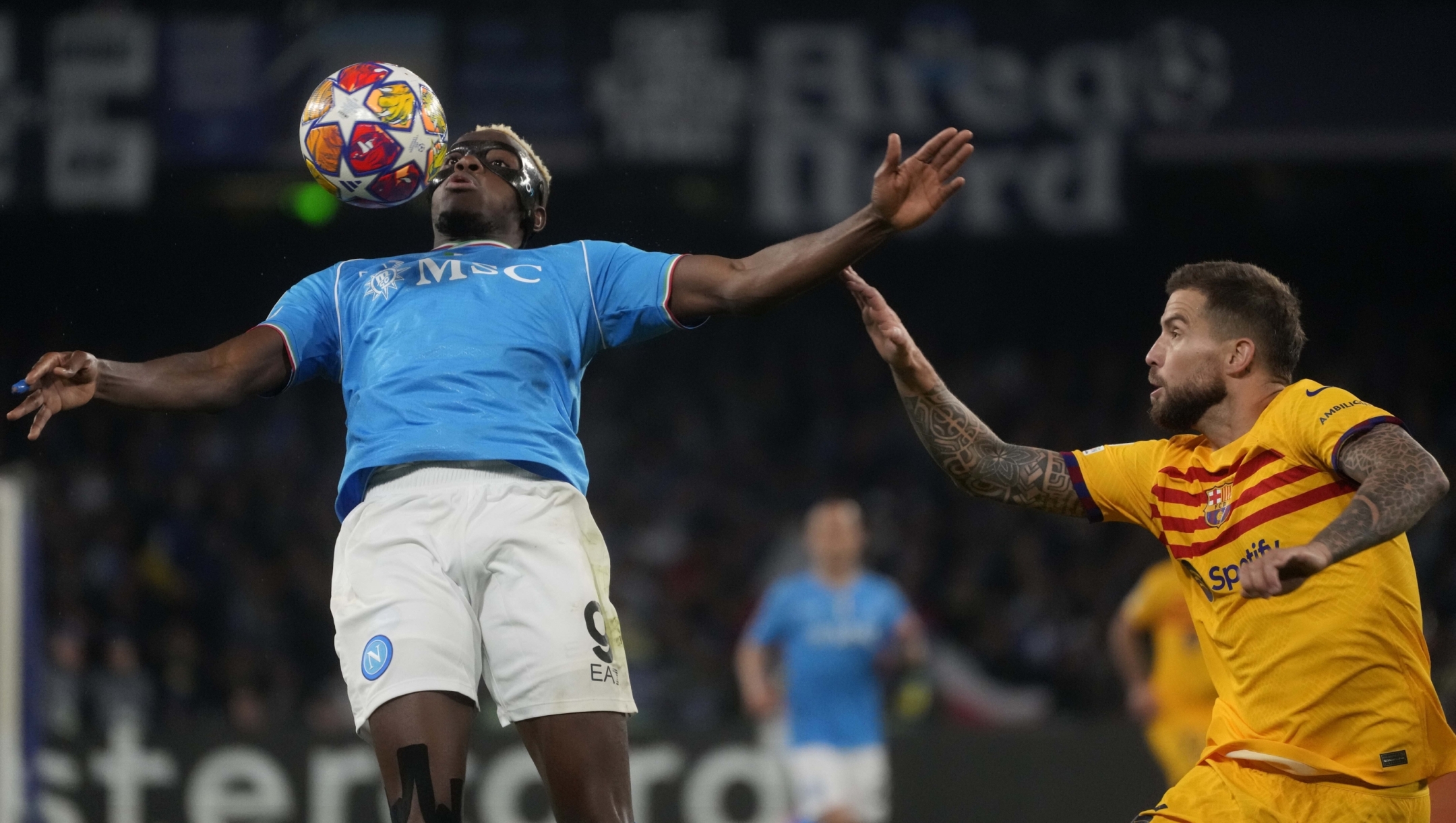 Napoli's Victor Osimhen, left, and Barcelona's Inigo Martinez challenge for the ball during the Champions League, round of 16, first leg soccer match between SSC Napoli and FC Barcelona at the Diego Maradona stadium in Naples, Italy, Wednesday, Feb. 21, 2024. (AP Photo/Gregorio Borgia)