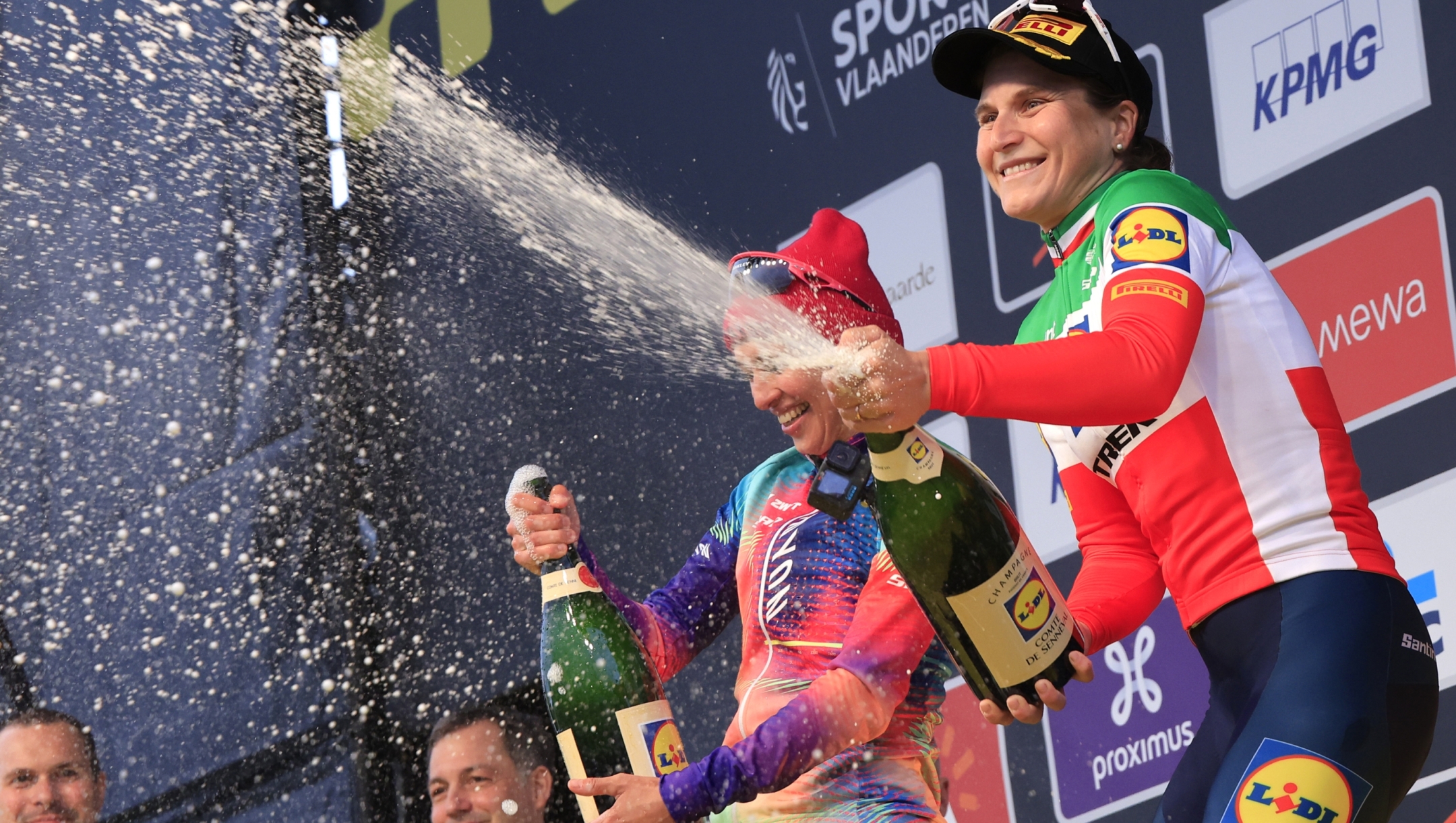First place, Elisa Longo-Borghini of the Lidl-Trek team, right, celebrates on the podium with second place, Kasia Niewiadoma of the Canyon-SRAM team, left, during the Tour of Flanders in Oudenaarde, Belgium on Sunday, March 31, 2024. (AP Photo/Geert Vanden Wijngaert)