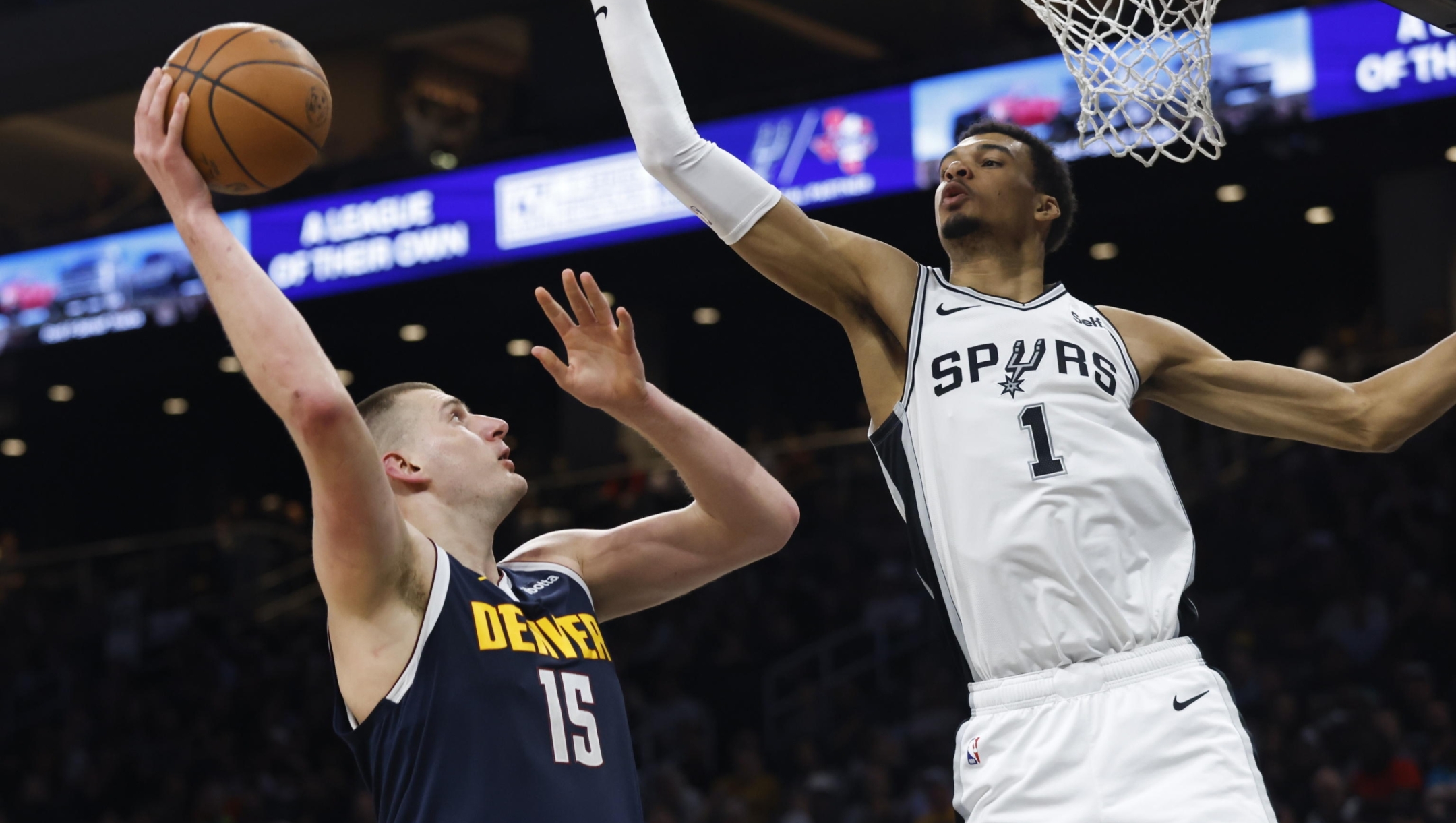 epa11223327 Denver Nuggets center Nikola Jokic of Serbia takes a shot over San Antonio Spurs center Victor Wembanyama of France during the first half of an NBA game between the San Antonio Spurs and the Denver Nuggets in Austin, Texas, USA, 15 March 2024.  EPA/ADAM DAVIS SHUTTERSTOCK OUT