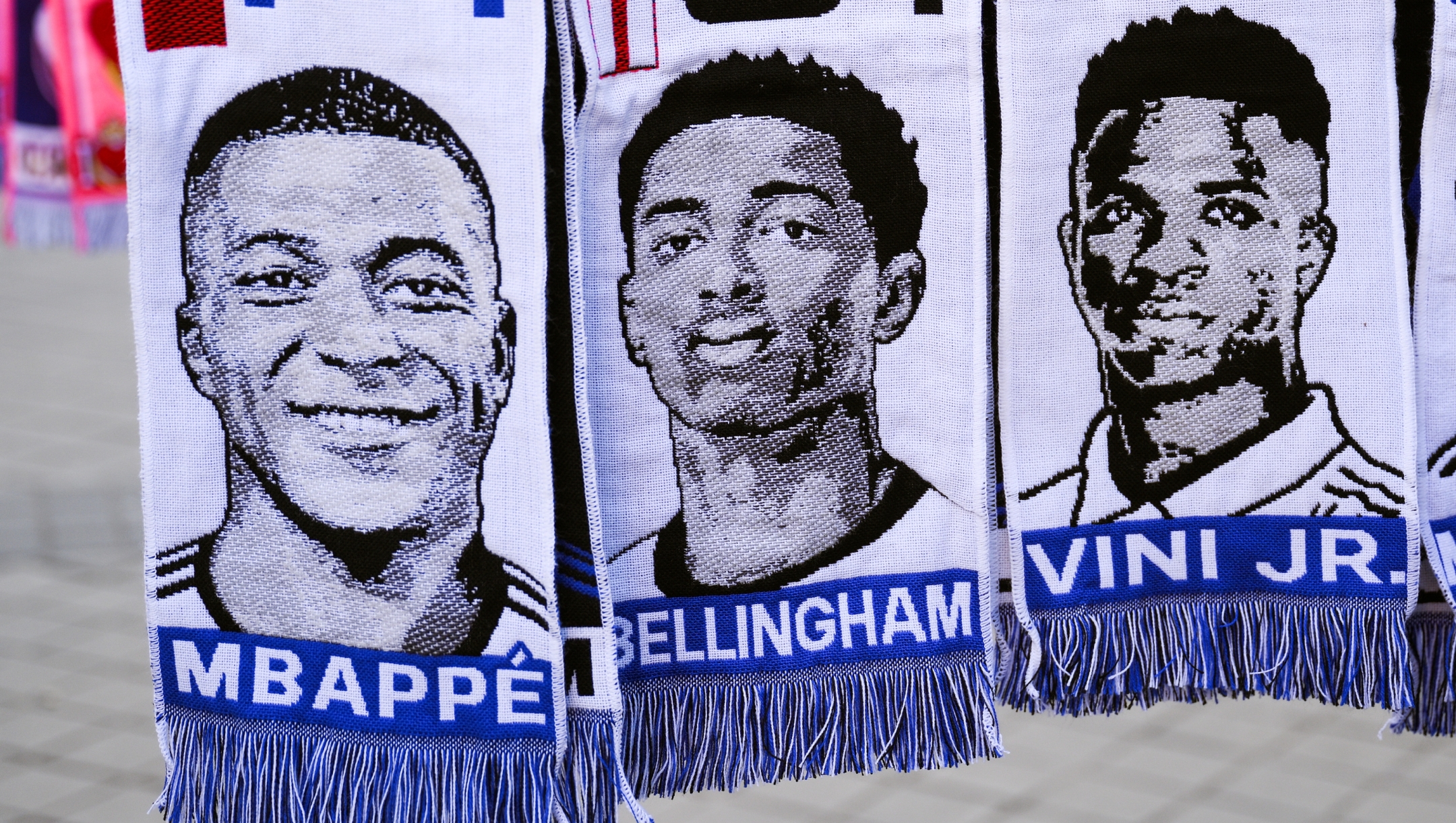 MADRID, SPAIN - MARCH 06: Scarves of Kylian Mbappe, Jude Bellingham and Vinicius Jr.hang in a souvenir stall outside the stadium prior to the UEFA Champions League 2023/24 round of 16 second leg match between Real Madrid CF and RB Leipzig at Estadio Santiago Bernabeu on March 06, 2024 in Madrid, Spain. (Photo by David Ramos/Getty Images)