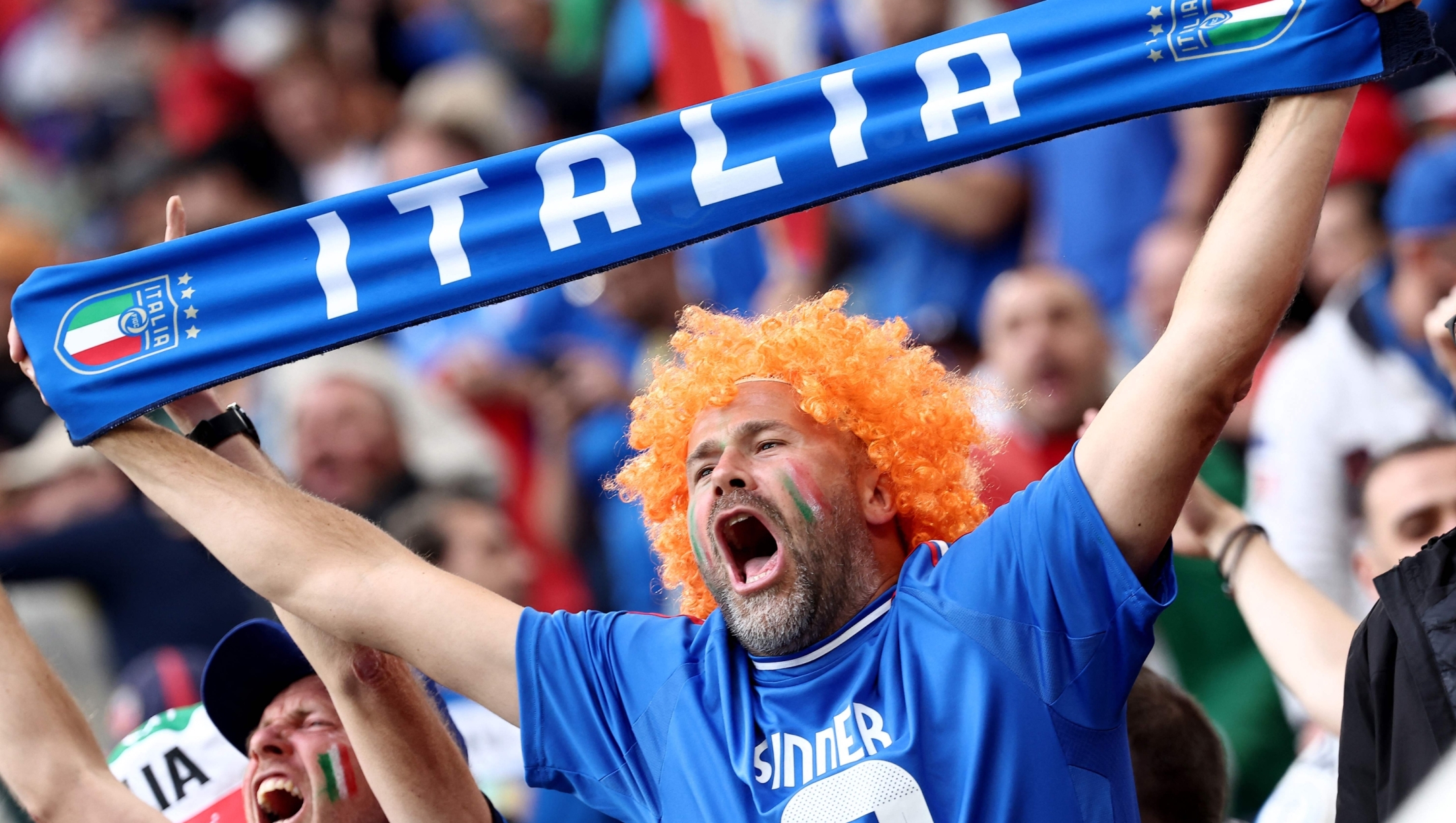 A fan of Italy cheers holding an Italian scarf prior the UEFA Euro 2024 Group B football match between Italy and Albania at the BVB Stadion in Dortmund, western Germany, on June 15, 2024. (Photo by FRANCK FIFE / AFP)