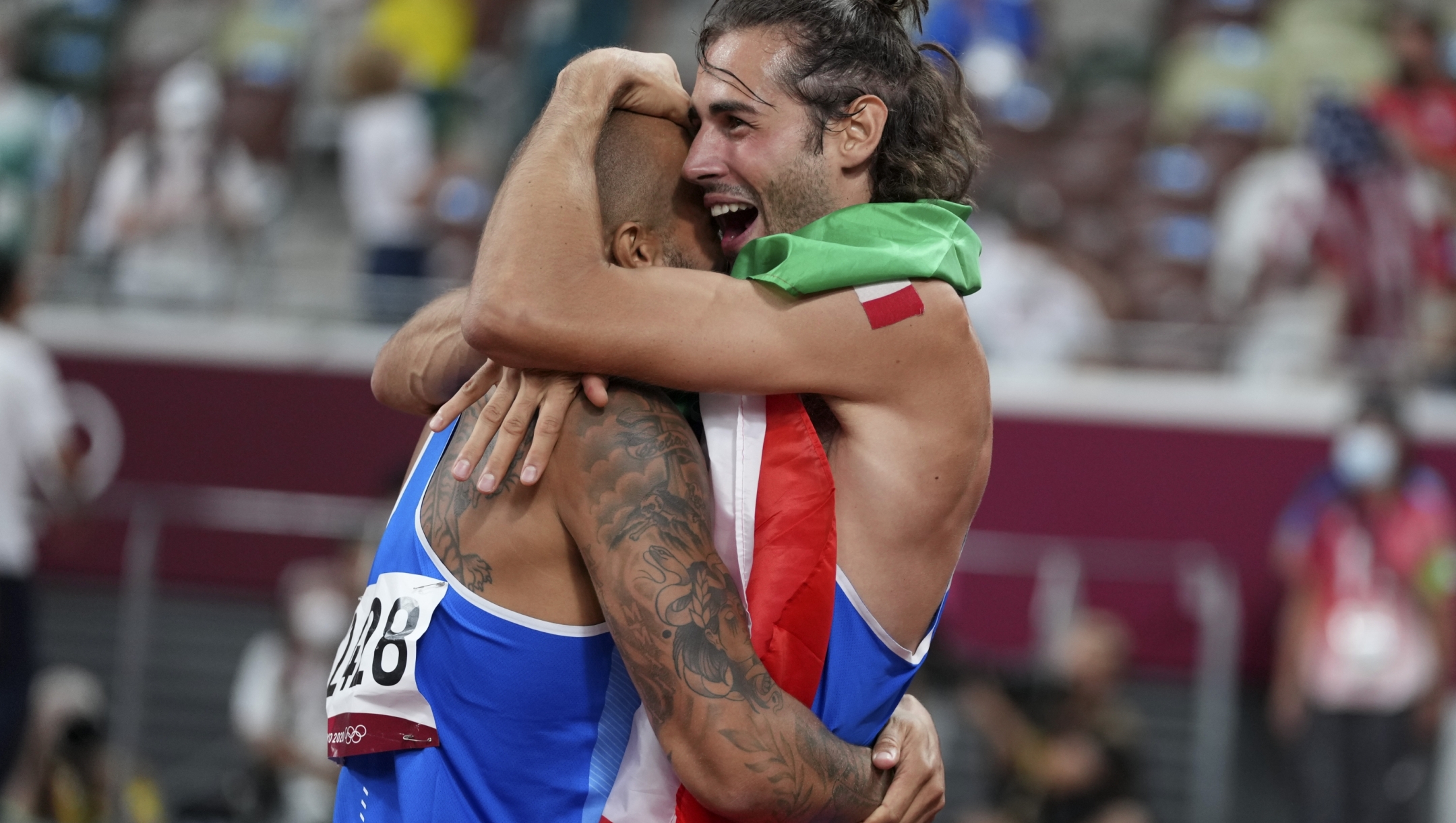 High jump gold medalist Gianmarco Tamberi, right, of Italy, congratulates compatriot Lamont Marcell Jacobs, after he won the final of the men's 100-meters at the 2020 Summer Olympics, Sunday, Aug. 1, 2021, in Tokyo. (AP Photo/Matthias Schrader)