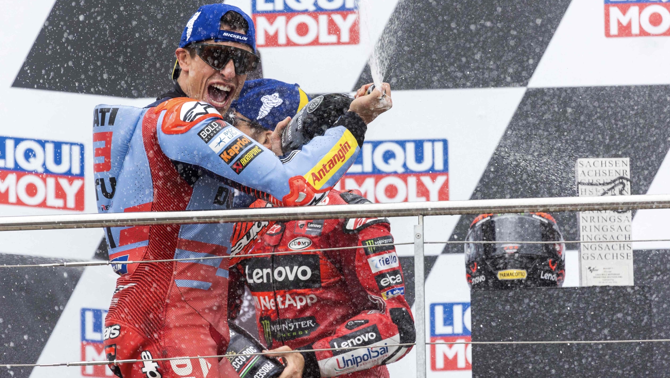 Winner Ducati Lenovo Team's Italian rider Francesco Bagnaia (R) and second placed Gresini Racing MotoGP's Spanish rider Marc Marquez celebrate on the podium after the German Motorcycle Grand Prix at the Sachsenring racetrack in Hohenstein-Ernstthal, eastern Germany, on July 7, 2024. (Photo by Radek Mica / AFP)