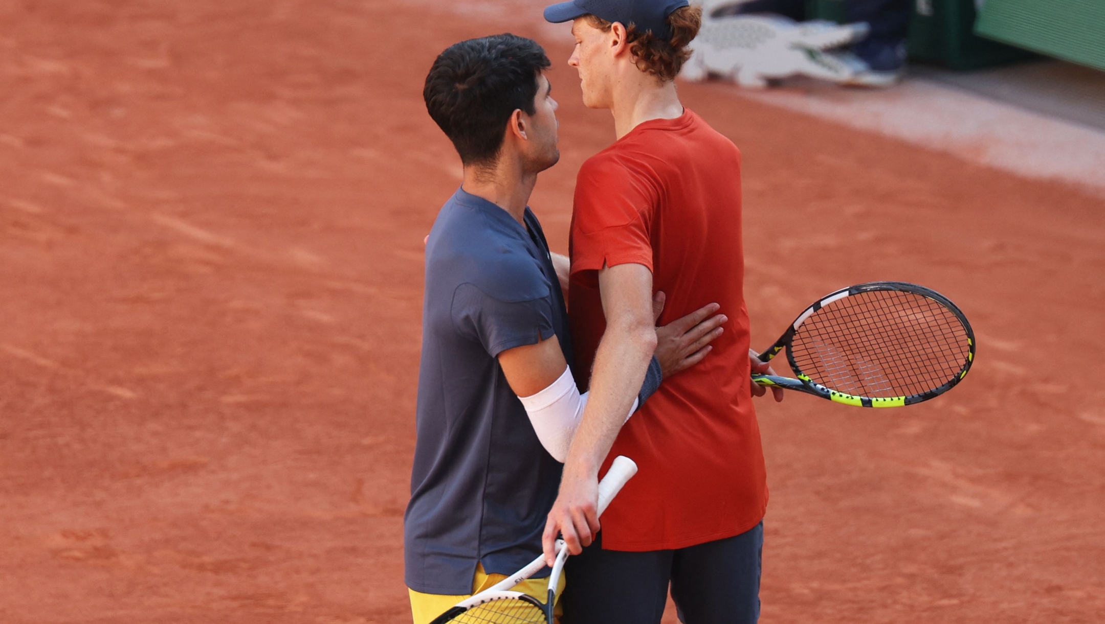 Spain's Carlos Alcaraz (L) speaks with Italy's Jannik Sinner after winning at the end of their men's singles semi final match on Court Philippe-Chatrier on day thirteen of the French Open tennis tournament at the Roland Garros Complex in Paris on June 7, 2024. (Photo by Alain JOCARD / AFP)