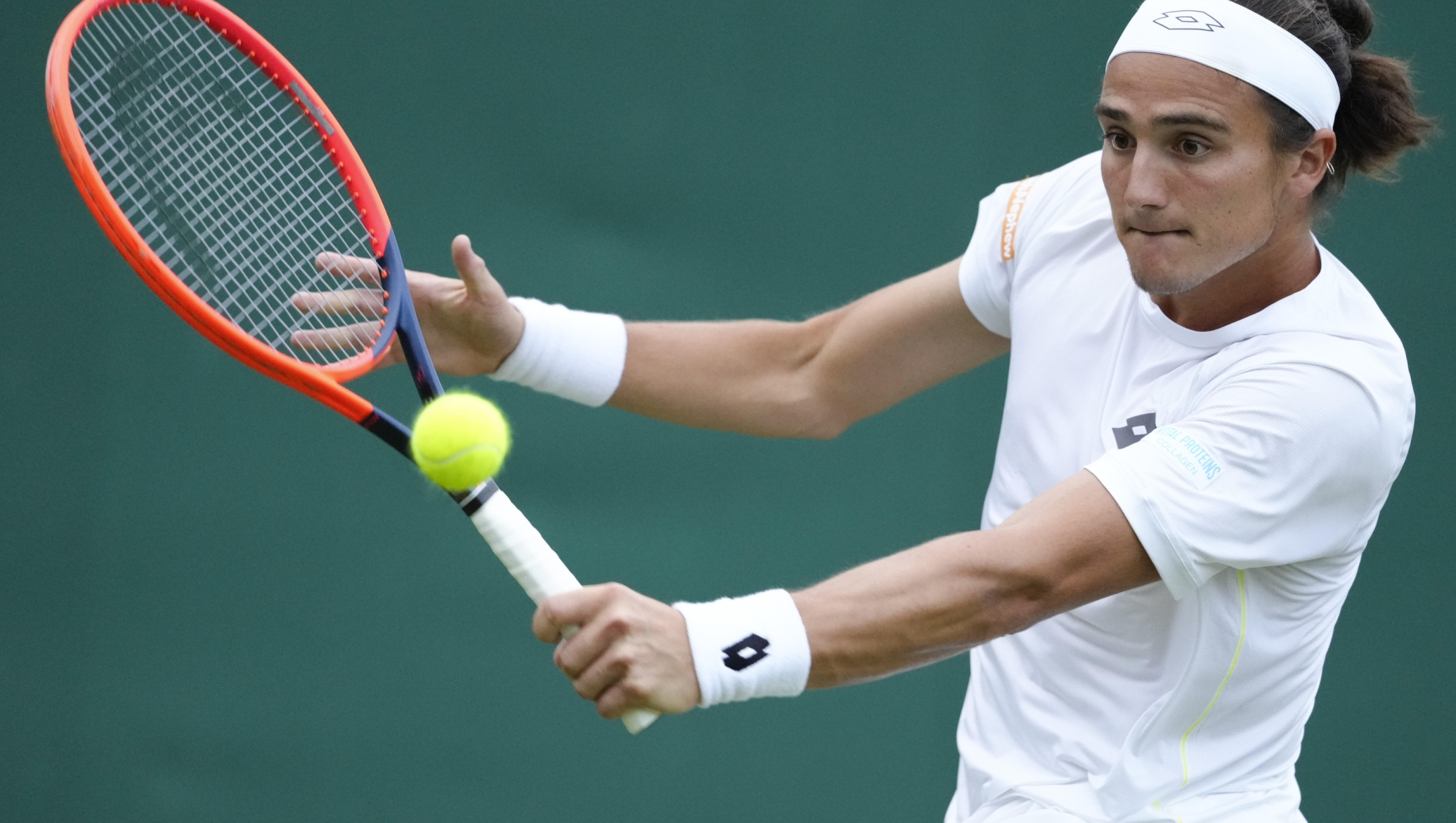 Mattia Bellucci of Italy plays a backhand return to Ben Shelton of the United States during their first round match at the Wimbledon tennis championships in London, Monday, July 1, 2024. (AP Photo/Kirsty Wigglesworth)