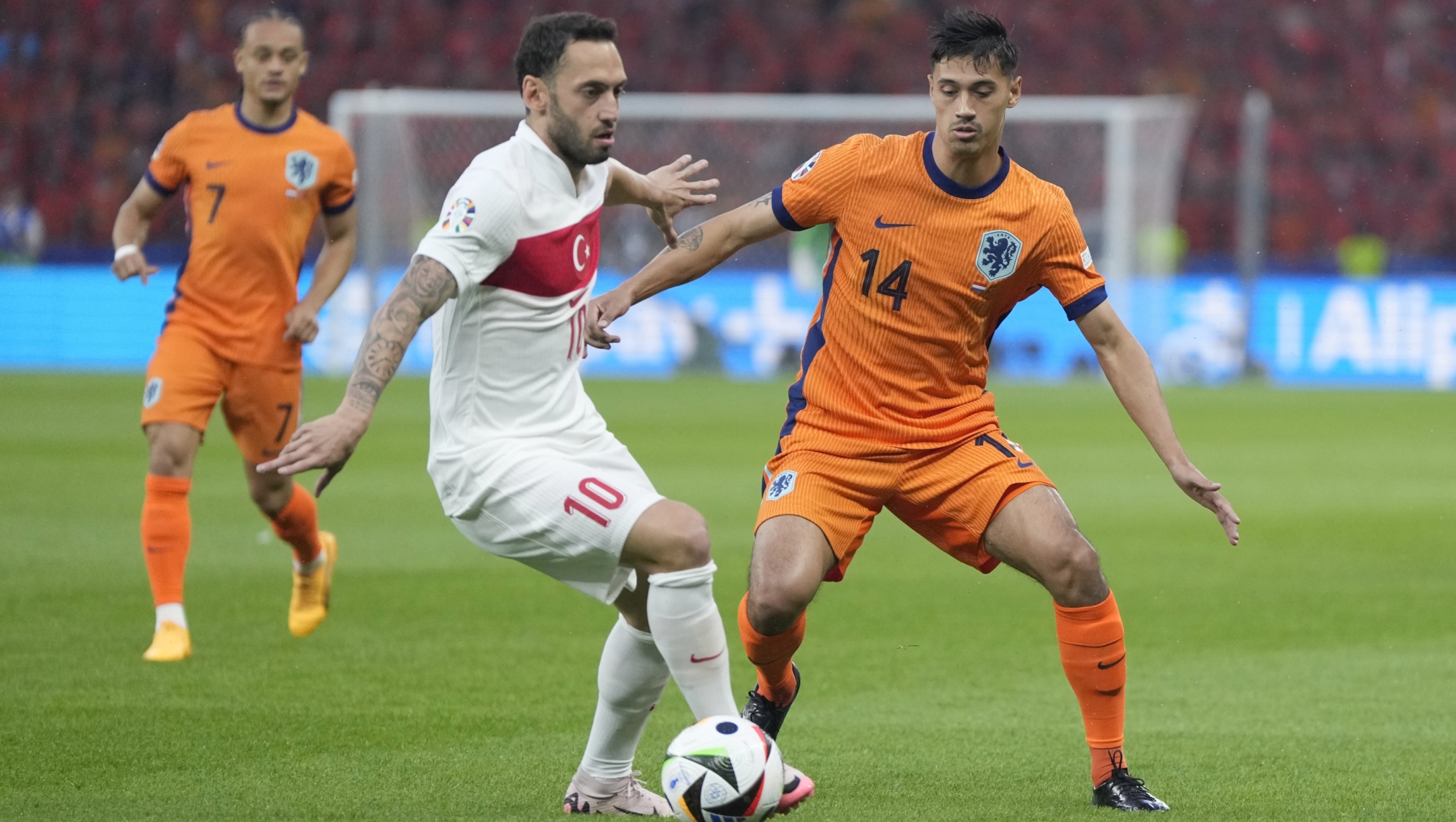 Tijjani Reijnders of the Netherlands, right, vies for the ball with Turkey's Hakan Calhanoglu during the quarterfinal match between the Netherlands and Turkey at the Euro 2024 soccer tournament in Berlin, Germany, Saturday, July 6, 2024. (AP Photo/Matthias Schrader)