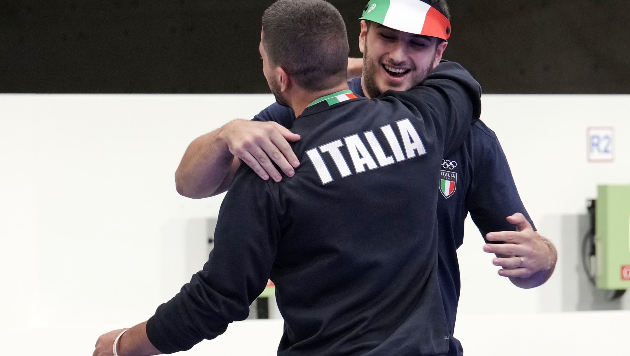Italy's Frederico Nilo Maldini, facing the camera, hugs fellow countryman Italy's Paolo Monna after finishing second and third respectively in the 10m air pistol men's final at the 2024 Summer Olympics, Sunday, July 28, 2024, in Chateauroux, France. (AP Photo/Manish Swarup)