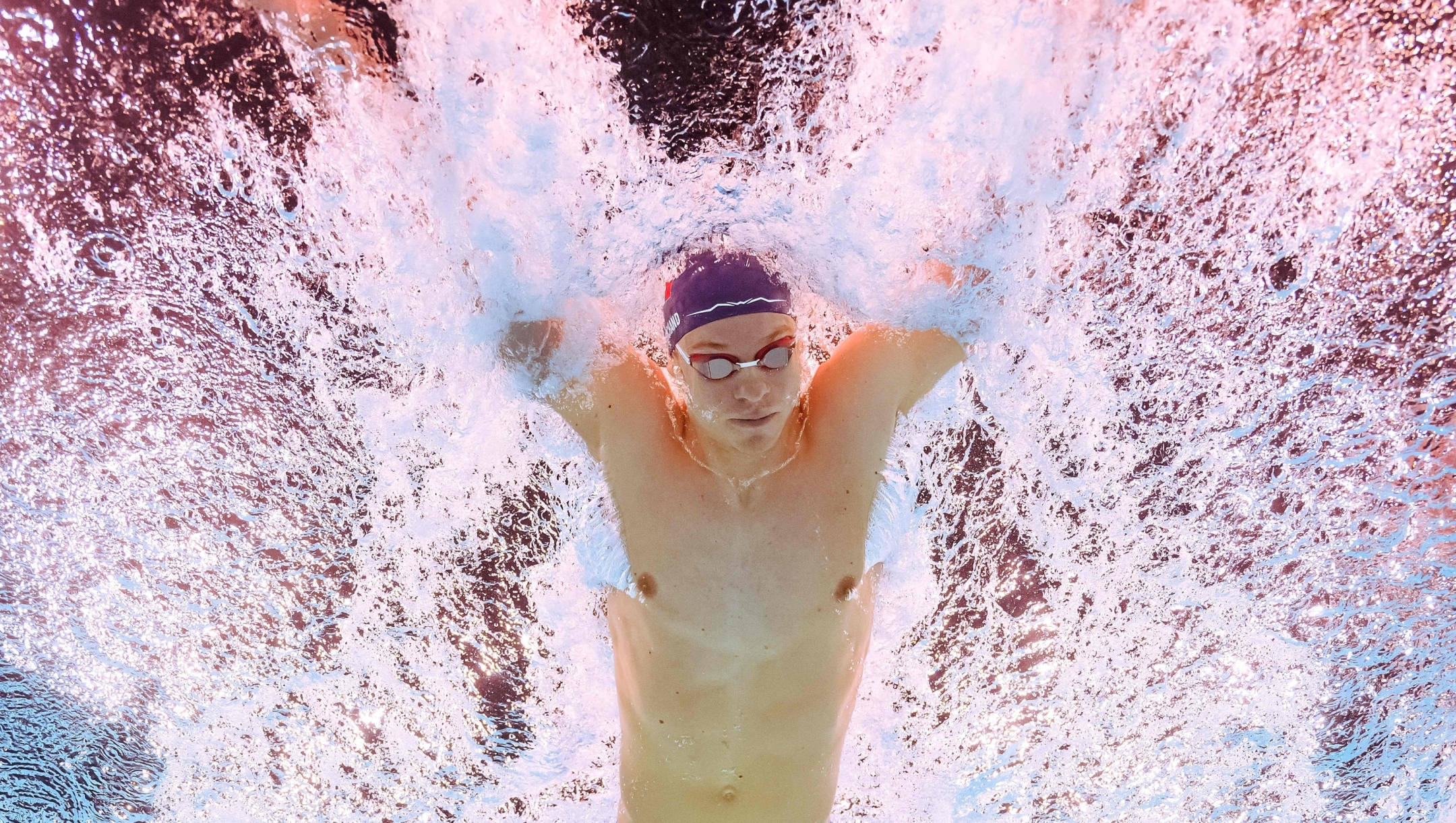 TOPSHOT - An underwater view shows Frances Leon Marchand competing in the heats of the men's 200m individual medley swimming event during the Paris 2024 Olympic Games at the Paris La Defense Arena in Nanterre, west of Paris on August 1, 2024. (Photo by Manan VATSYAYANA / AFP)