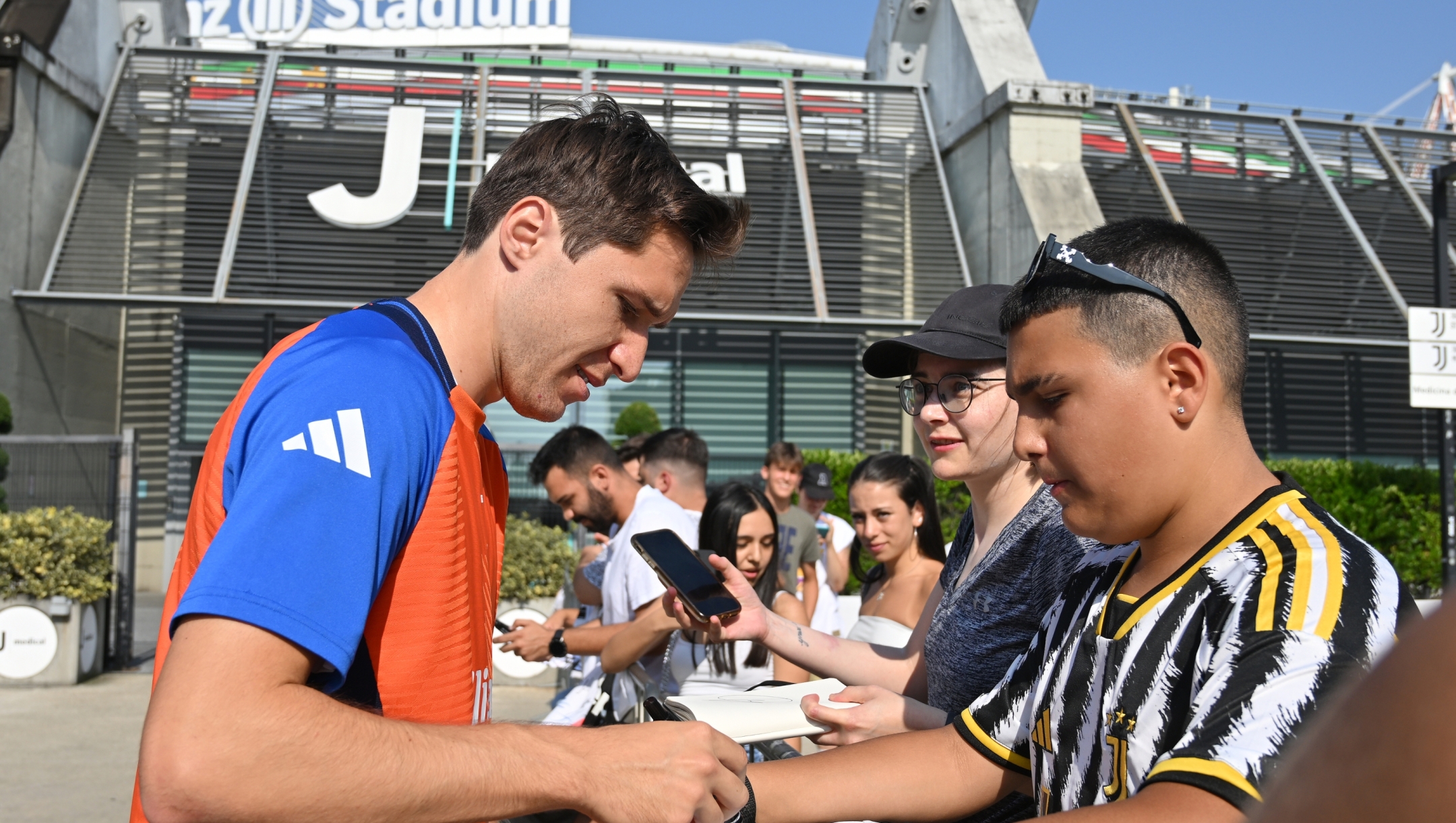 TURIN, ITALY - JULY 23: Federico Chiesa of Juventus FC greets fans and takes photos and signs autographs after he arrives for medical tests and first day back in training on July 23, 2024 in Turin, Italy. (Photo by Chris Ricco - Juventus FC/Juventus FC via Getty Images)