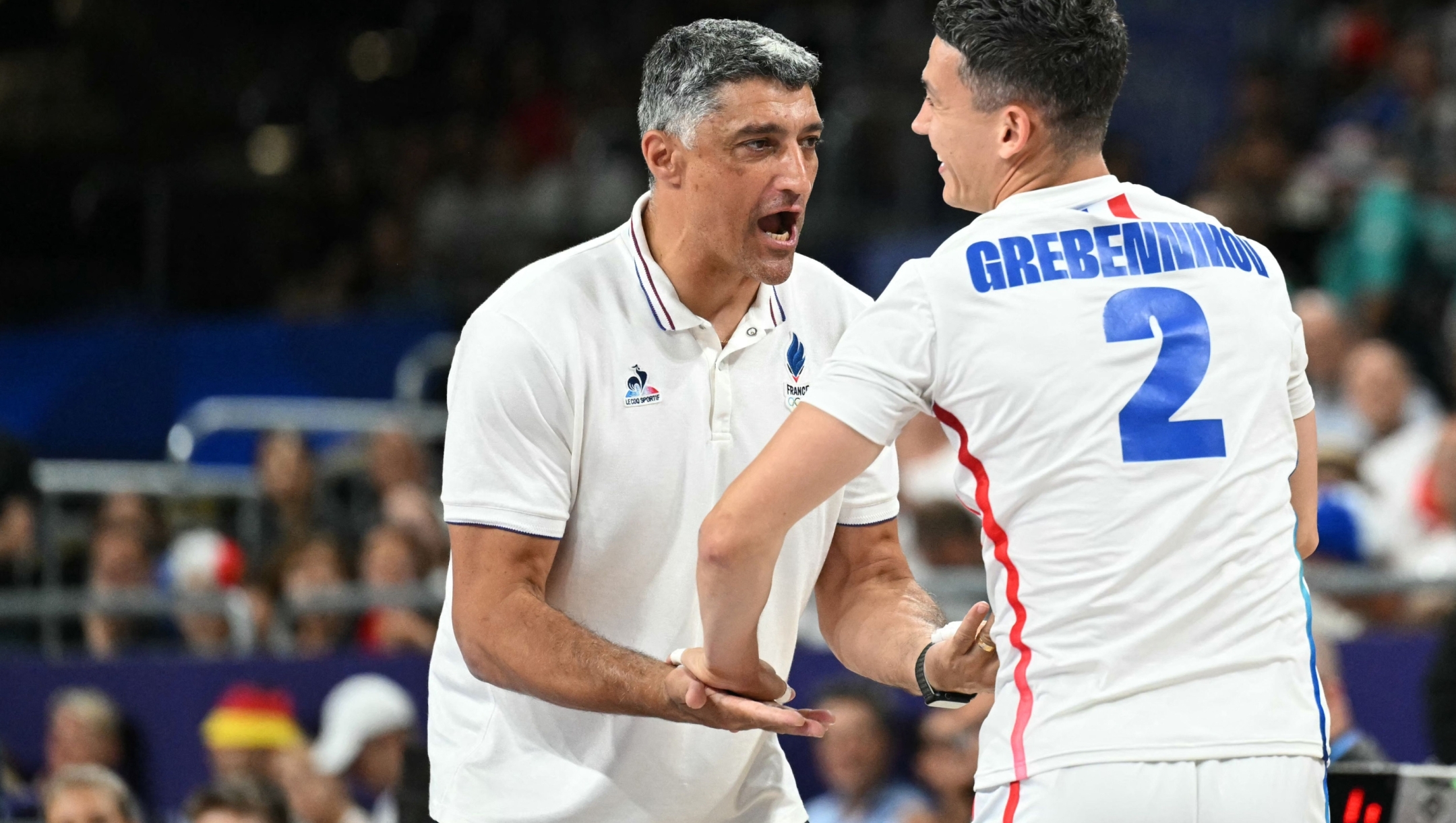 France's Italian head coach Andrea Giani (L) reacts with France's #02 Jenia Grebennikov at the start of the men's preliminary round volleyball match between France and Slovenia during the Paris 2024 Olympic Games at the South Paris Arena 1 in Paris on August 2, 2024. (Photo by Natalia KOLESNIKOVA / AFP)