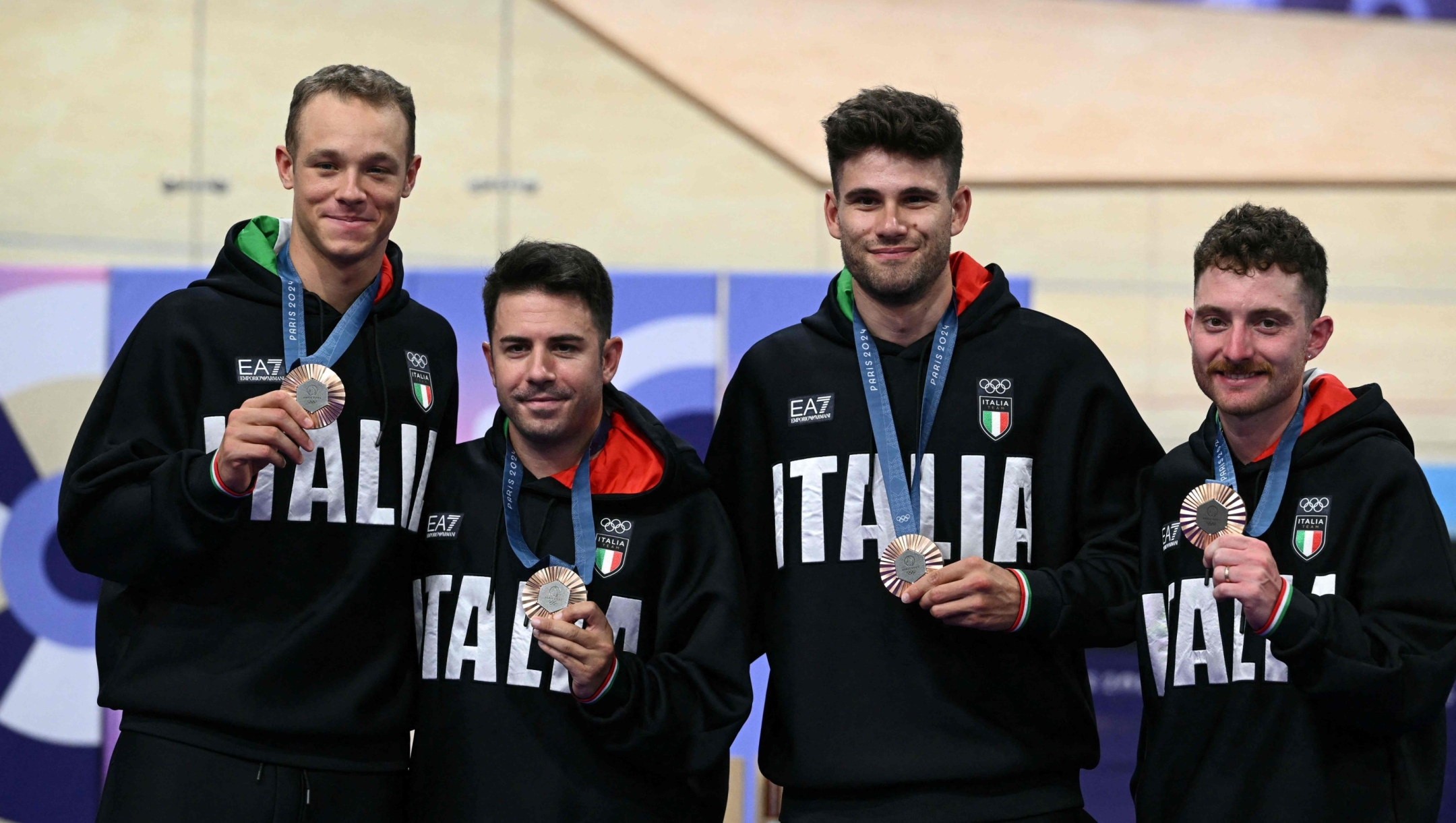 Bronze medallists Italy's Jonathan Milan, Italy's Francesco Lamon, Italy's Filippo Ganna and Italy's Simone Consonni pose   on the podium of the men's track cycling team pursuit event of the Paris 2024 Olympic Games at the Saint-Quentin-en-Yvelines National Velodrome in Montigny-le-Bretonneux, south-west of Paris, on August 7, 2024. (Photo by SEBASTIEN BOZON / AFP)