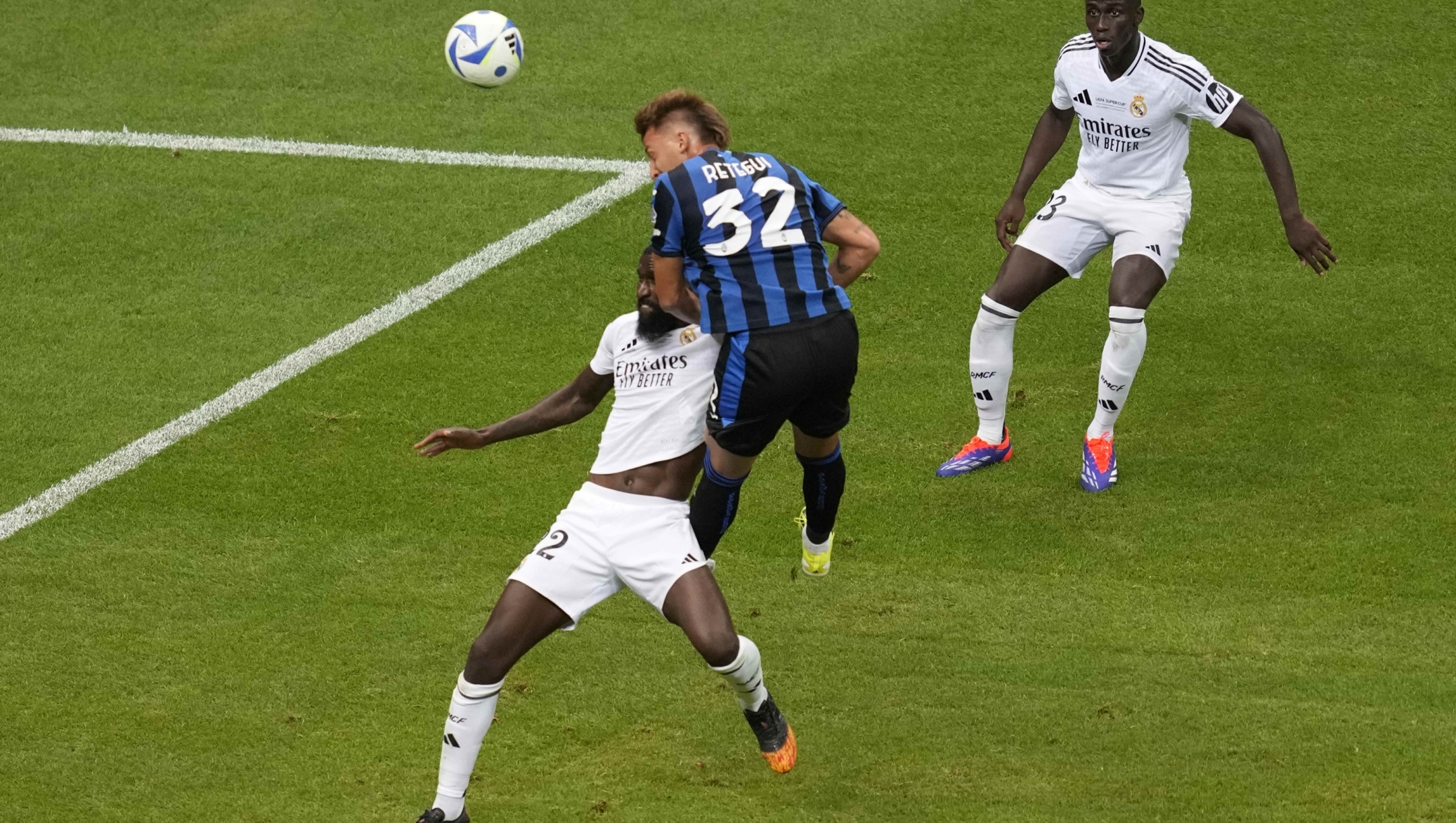 Atalanta's Mateo Retegui, center, attempts a head at goal in front of Real Madrid's Antonio Ruediger, left, during the UEFA Super Cup Final soccer match between Real Madrid and Atalanta at the Narodowy stadium in Warsaw, Poland, Wednesday, Aug. 14, 2024. (AP Photo/Darko Vojinovic)