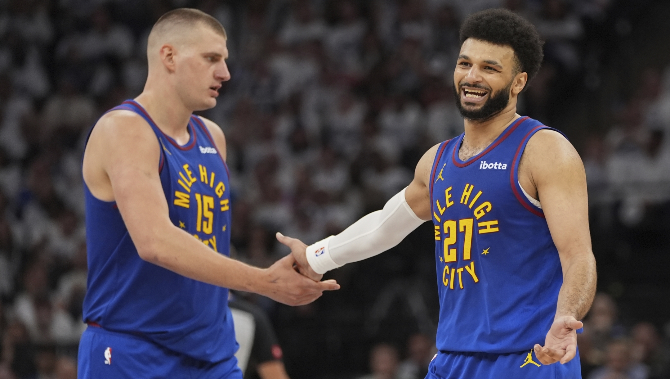 Denver Nuggets center Nikola Jokic (15) and guard Jamal Murray (27) slap hands during the second half of Game 3 of an NBA basketball second-round playoff series against the Minnesota Timberwolves, Friday, May 10, 2024, in Minneapolis. (AP Photo/Abbie Parr)