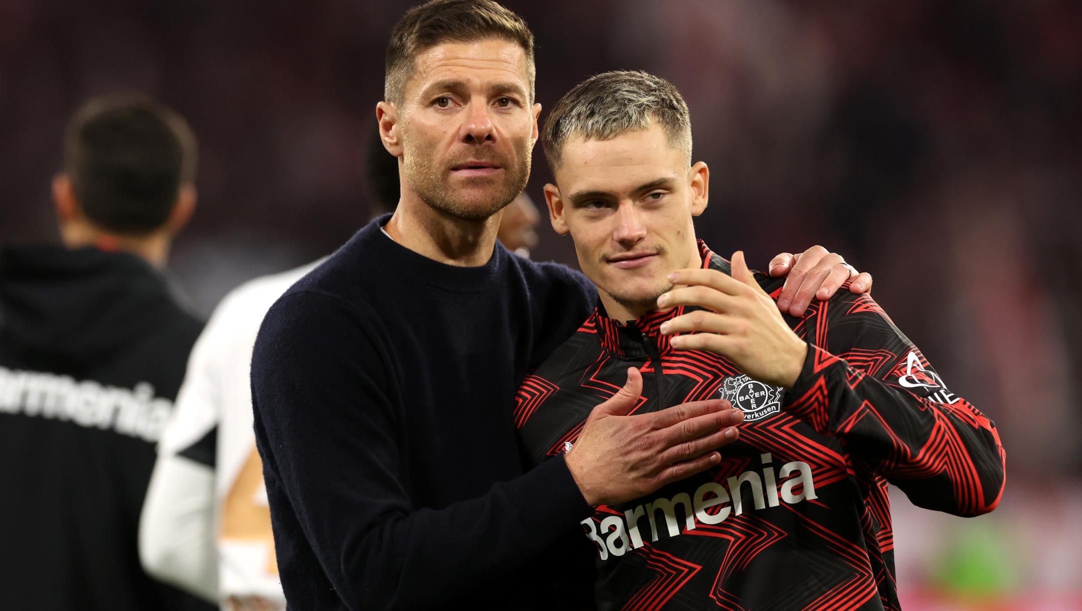 MUNICH, GERMANY - SEPTEMBER 28: Xabi Alonso, Head Coach of Bayer 04 Leverkusen, embraces Florian Wirtz of Bayer 04 Leverkusen a full-time following the team's draw in the Bundesliga match between FC Bayern München and Bayer 04 Leverkusen at Allianz Arena on September 28, 2024 in Munich, Germany. (Photo by Alexander Hassenstein/Getty Images)