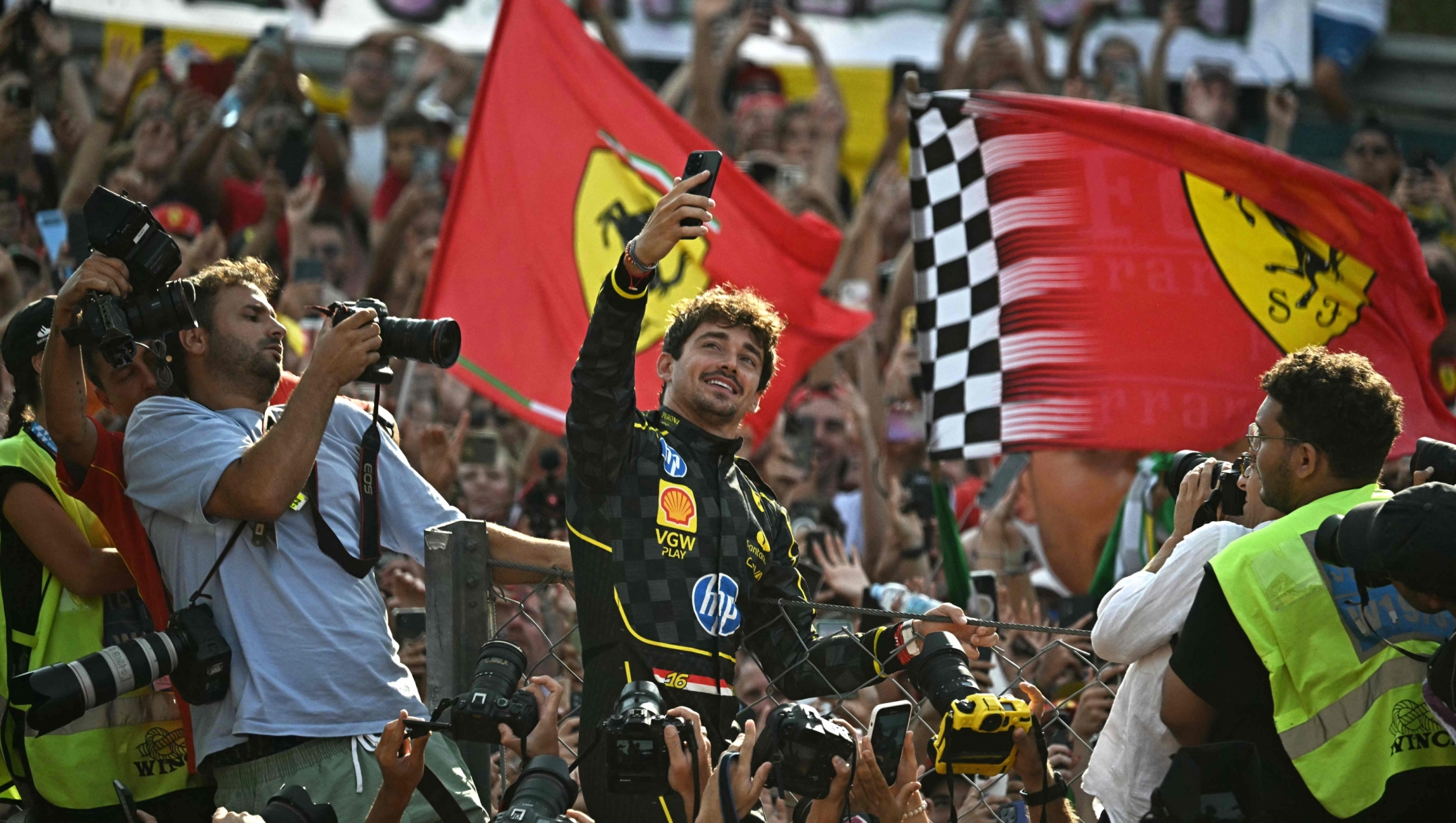 TOPSHOT - Ferrari's Monegasque driver Charles Leclerc takes a selfie picture with supporters after winning the Italian Formula One Grand Prix race at Autodromo Nazionale Monza circuit, in Monza on September 1, 2024. (Photo by Gabriel BOUYS / AFP)