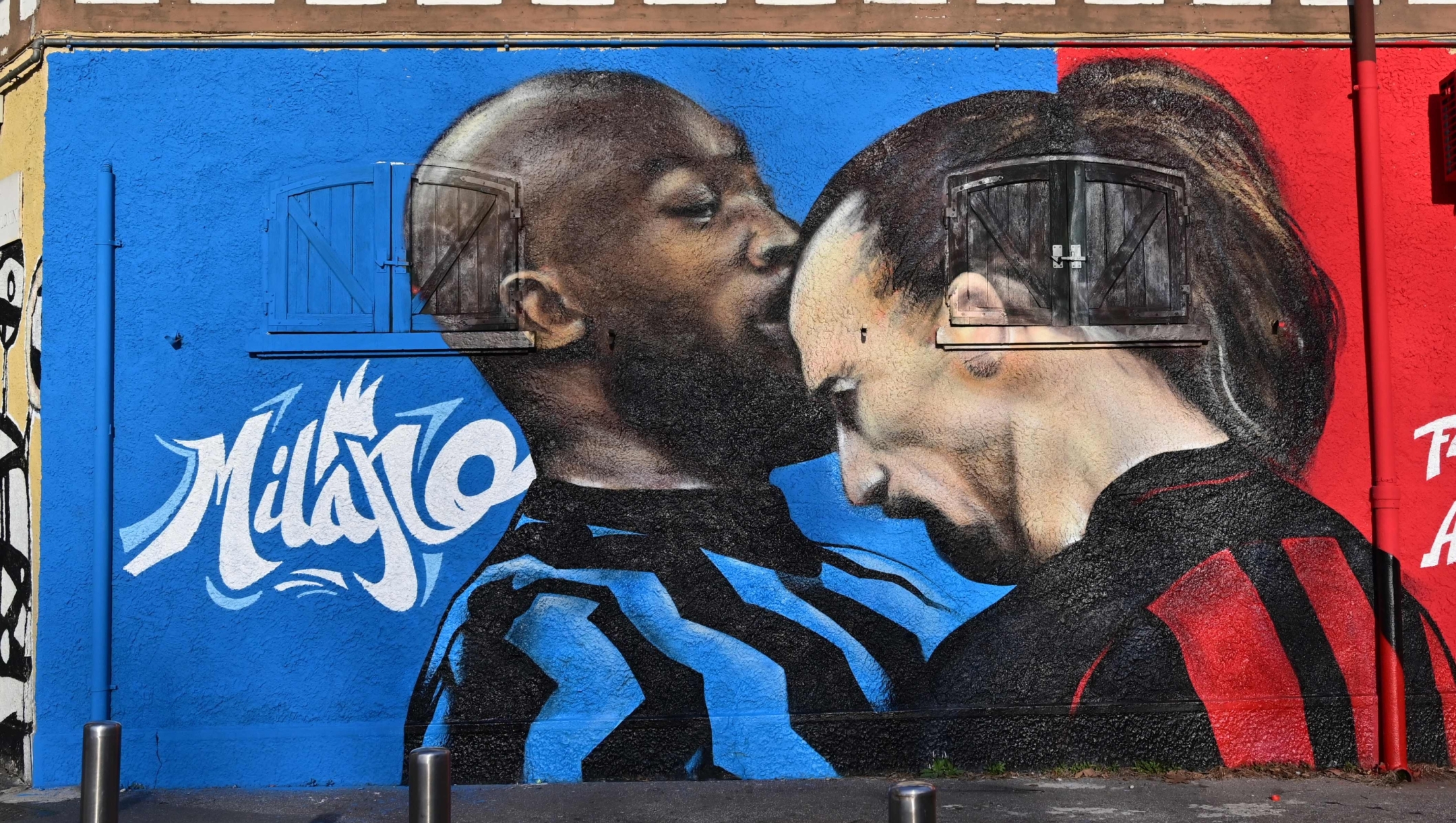 A picture taken in Milan on February 15, 2021 shows a street art mural by an unknown artist on a wall near the San Siro stadium, depicting AC Milan's Swedish forward Zlatan Ibrahimovic headbutting Inter Milan's Belgian forward Romelu Lukaku, a gesture that occured last January 26 during their Italian Cup quarter final match. (Photo by MIGUEL MEDINA / AFP) / RESTRICTED TO EDITORIAL USE - MANDATORY MENTION OF THE ARTIST UPON PUBLICATION - TO ILLUSTRATE THE EVENT AS SPECIFIED IN THE CAPTION