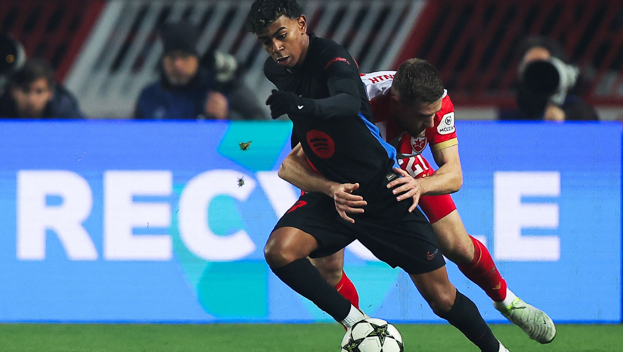 Barcelona's Spanish forward #19 Lamine Yamal (L) fights for the ball with Crvena Zvezda Beograd's Slovenian midfielder #21 Timi Elsnik during the UEFA Champions League, League phase - Matchday 4 football match between Crvena Zvezda Beograd and FC Barcelona, at the Rajko-Mitic Stadium, in Belgrade, on November 6, 2024. (Photo by Pedja Milosavljevic / AFP)