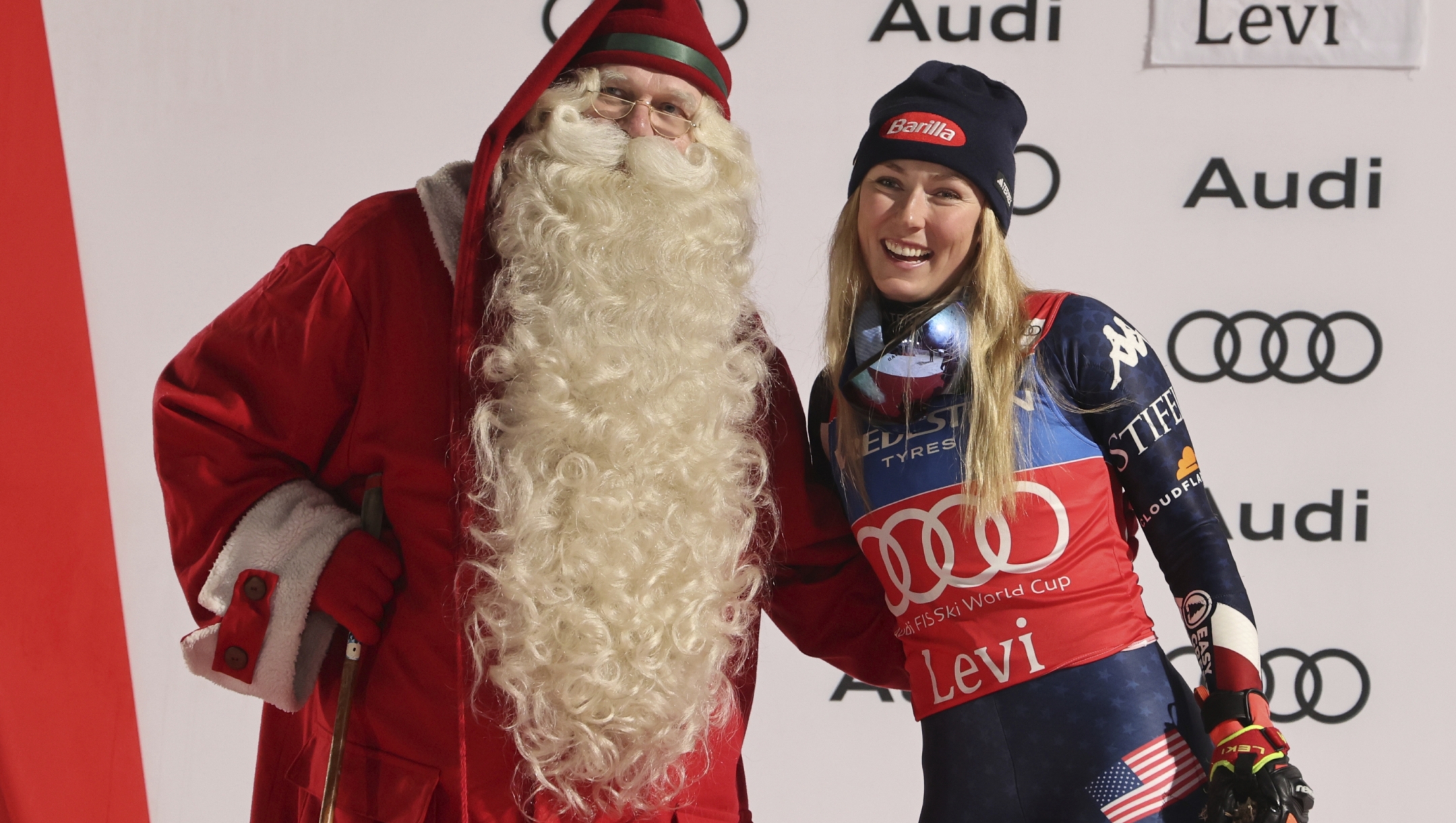 The winner United States' Mikaela Shiffrin celebrates on podium with Santa, after an alpine ski, women's World Cup slalom, in Levi, Finland, Saturday, Nov. 16, 2024. (AP Photo/Marco Trovati)    Associated Press / LaPresse Only italy and Spain