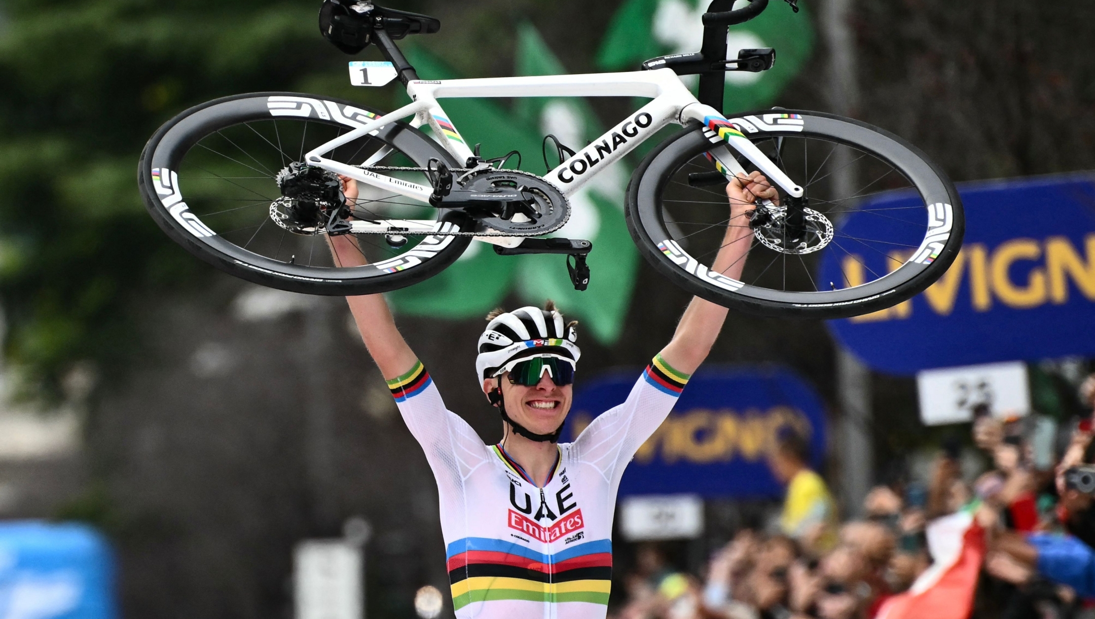 UAE Team Emirates team's Slovenian rider Tadej Pogacar raises his bicycle after crossing the finish line to win the 118th edition of the Giro di Lombardia (Tour of Lombardy), a 252km cycling race from Bergamo to Como on October 12, 2024. (Photo by Marco BERTORELLO / AFP)