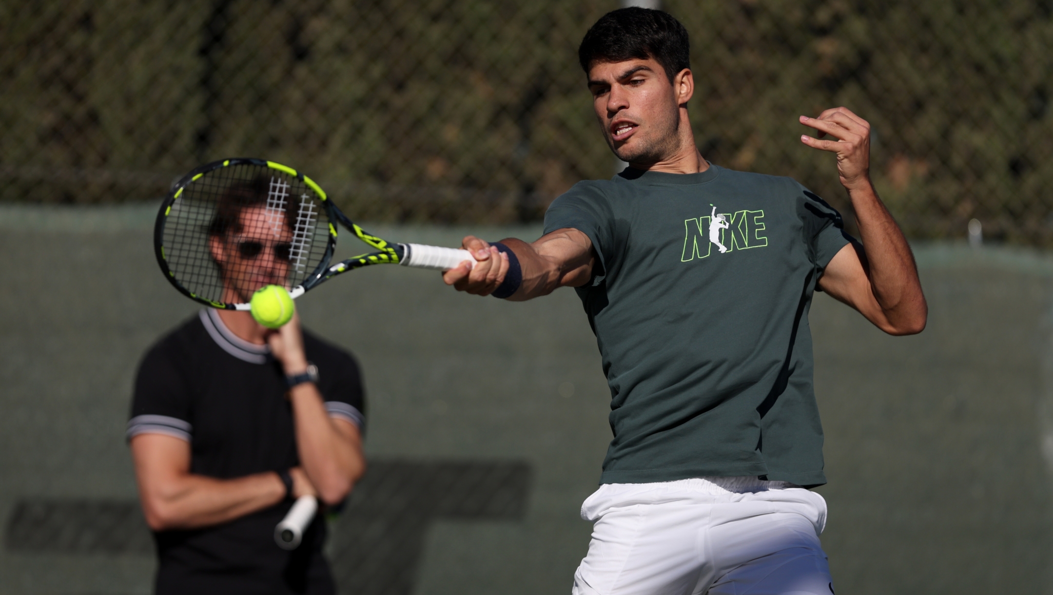 MURCIA, SPAIN - DECEMBER 12: Carlos Alcaraz of Spain plays a forehand watched by his coach Juan Carlos Ferrero during a pre season practice session at Real Sociedad Club de Campo Murcia on December 12, 2024 in Murcia, Spain. (Photo by Clive Brunskill/Getty Images)