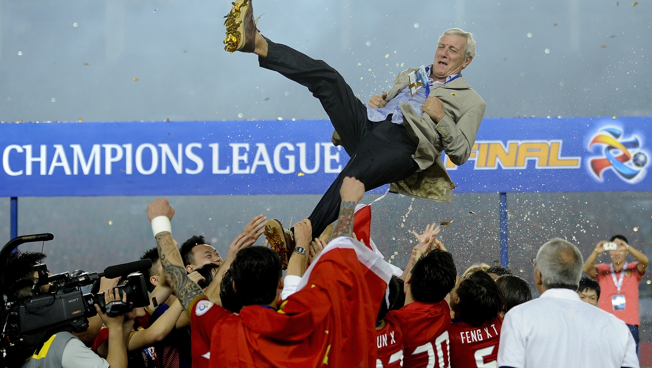 China's Guangzhou Evergrande players throw their coach Marcello Lippi into the air after winning the final match against South Korea's FC Seoul at the 2013 Asian Champions League final at Tianhe stadium in Guangzhou in south China's Guangdong province, Saturday, Nov. 9, 2013. Guangzhou Evergrande became the first Chinese team since 1990 to win the Asian Champions League by drawing 1-1 with FC Seoul in the second leg of the final on Saturday, claiming the title on away goals after the first game in South Korea ended 2-2. (AP Photo) CHINA OUT