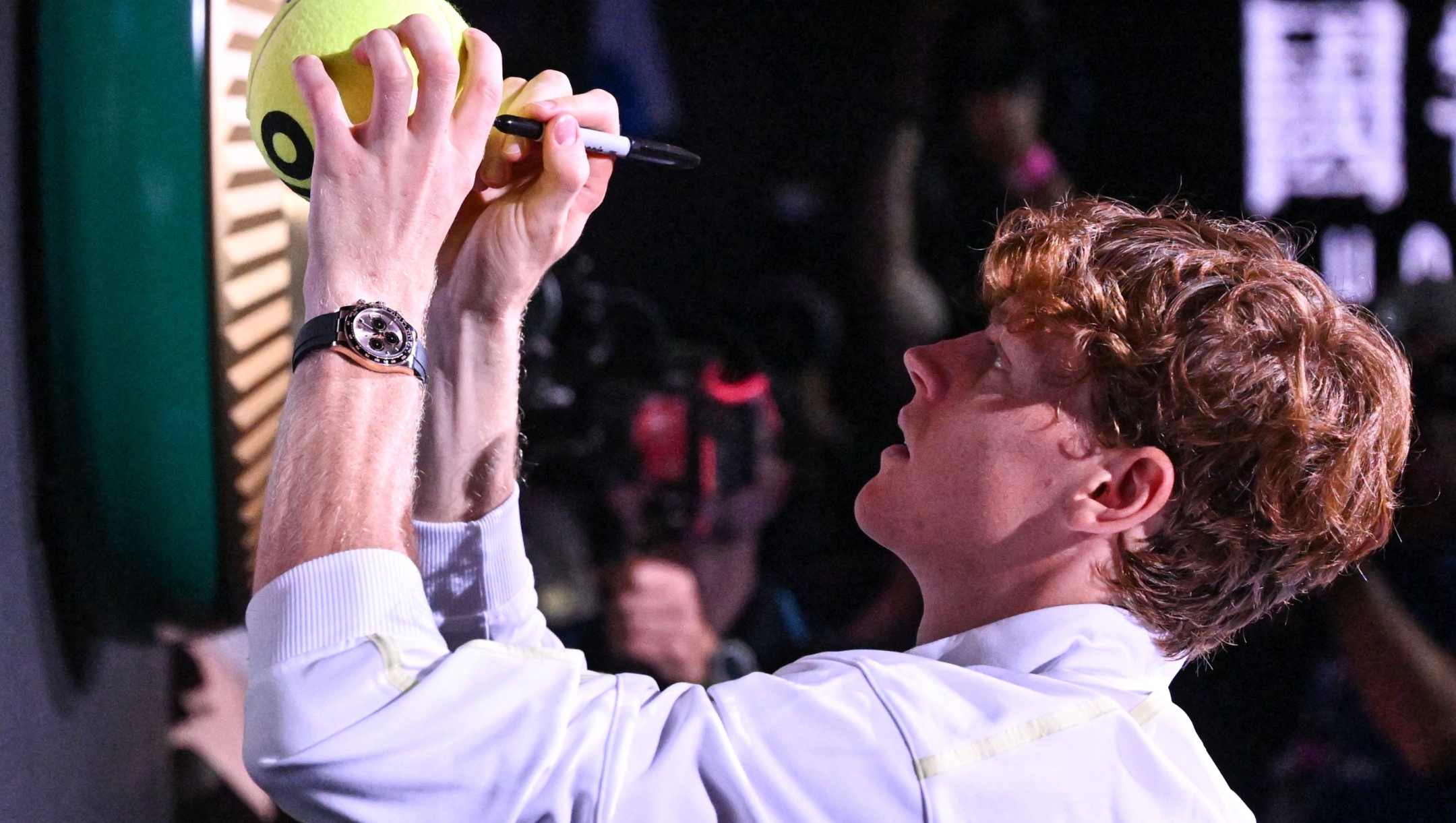 Italy's Jannik Sinner signs autographs as he leaves after his victory against Germany's Alexander Zverev during their men's singles final match on day fifteen of the Australian Open tennis tournament in Melbourne on January 26, 2025. (Photo by WILLIAM WEST / AFP) / -- IMAGE RESTRICTED TO EDITORIAL USE - STRICTLY NO COMMERCIAL USE --