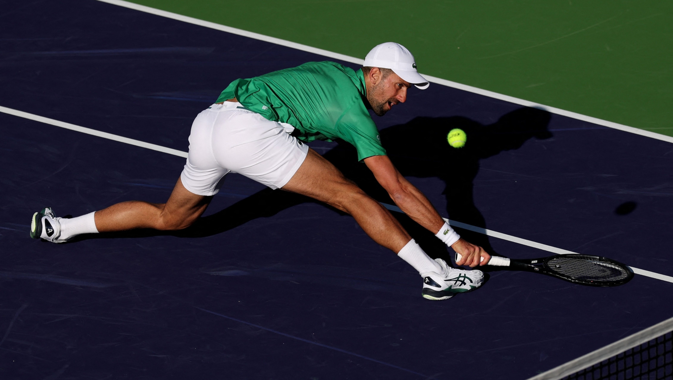 INDIAN WELLS, CALIFORNIA - MARCH 08: Novak Djokovic of Serbia stretches to play a backhand volley against Botic van de Zandschulp of the Netherlands in their second round match during the BNP Paribas Open at Indian Wells Tennis Garden on March 08, 2025 in Indian Wells, California.   Clive Brunskill/Getty Images/AFP (Photo by CLIVE BRUNSKILL / GETTY IMAGES NORTH AMERICA / Getty Images via AFP)