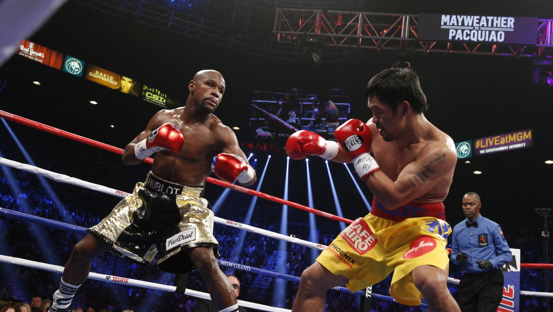 Floyd Mayweather Jr., and Manny Pacquiao (R) fight in a welterweight unification bout on May 2, 2015 at the MGM Grand Garden Arena in Las Vegas, Nevada. AFP PHOTO / JOHN GURZINKSI (Photo by JOHN GURZINSKI / AFP)