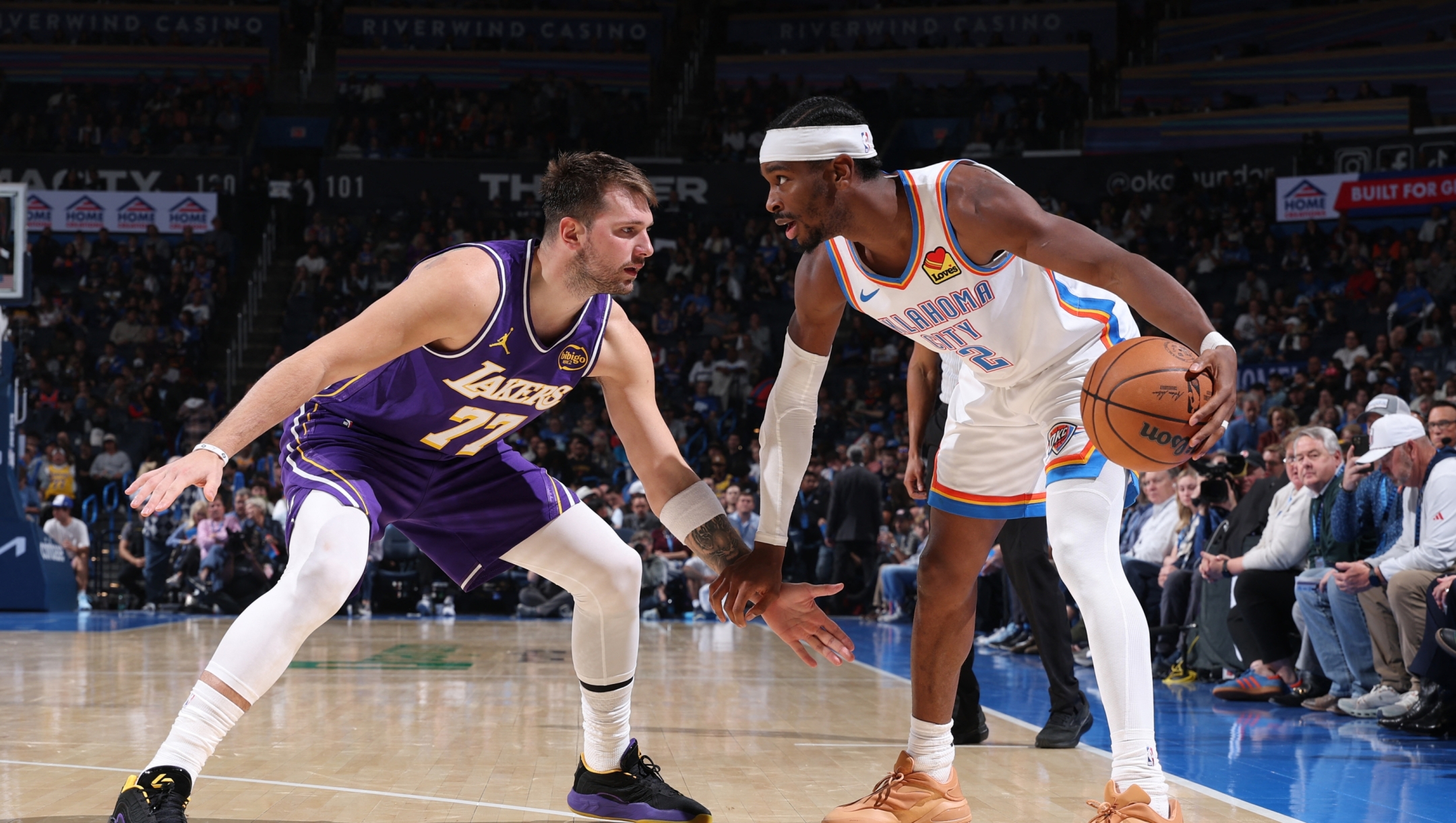  Shai Gilgeous-Alexander #2 of the Oklahoma City Thunder looks to pass the ball as Luka Doncic #77 of the Los Angeles Lakers plays defense during the game on November 12, 2025 at Paycom Center in Oklahoma City, Oklahoma. NOTE TO USER: User expressly acknowledges and agrees that, by downloading and or using this photograph, User is consenting to the terms and conditions of the Getty Images License Agreement. Mandatory Copyright Notice: Copyright 2025 NBAE   Joe Murphy/NBAE via Getty Images/AFP (Photo by JOE MURPHY / NBAE / Getty Images / Getty Images via AFP)